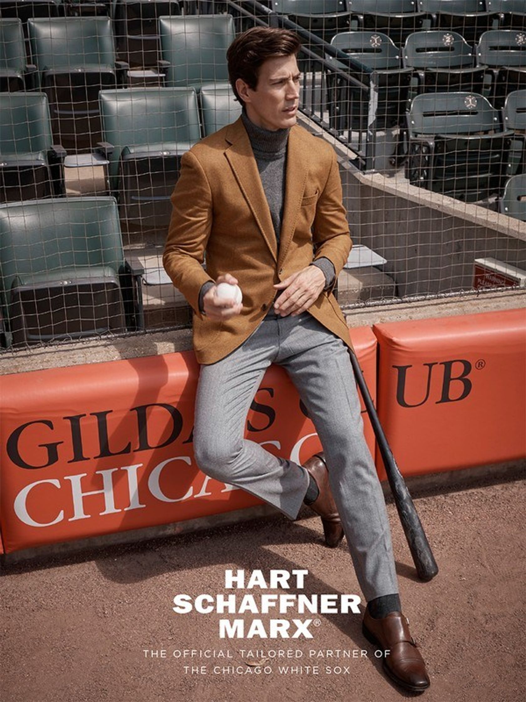 a man sitting on a baseball field with a baseball bat