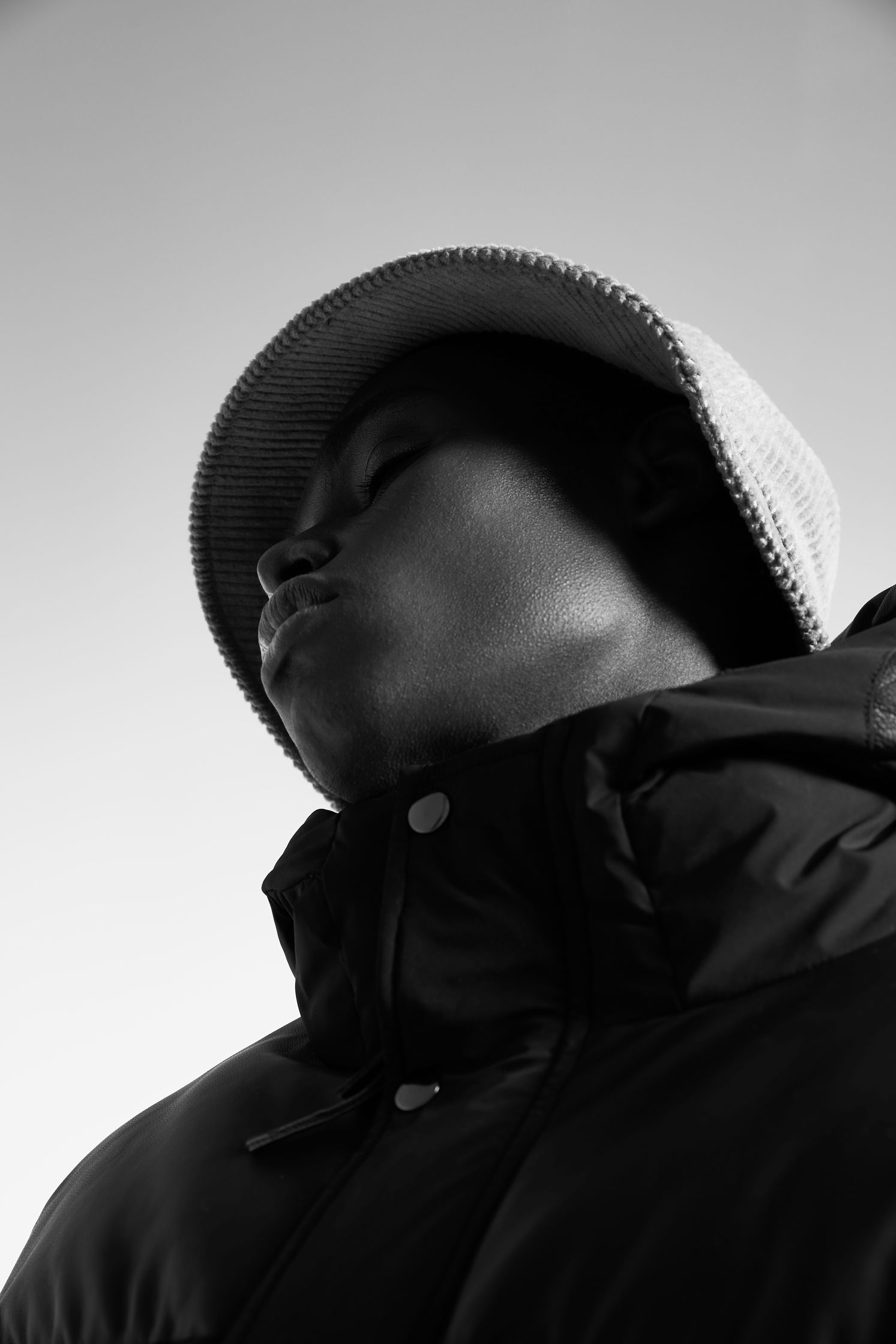 a black and white photo of a man wearing a hat