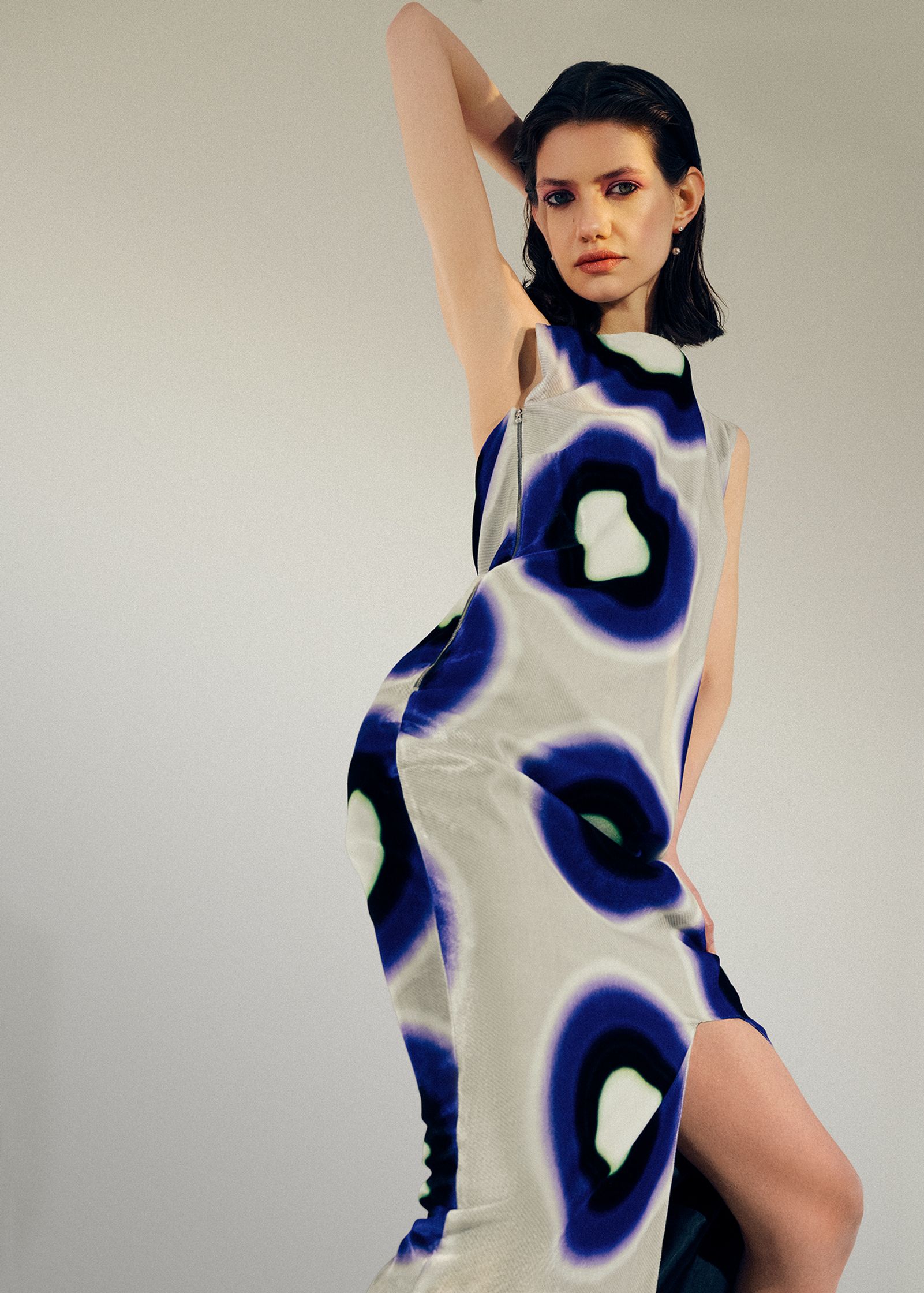 a woman is posing in a blue and white dress