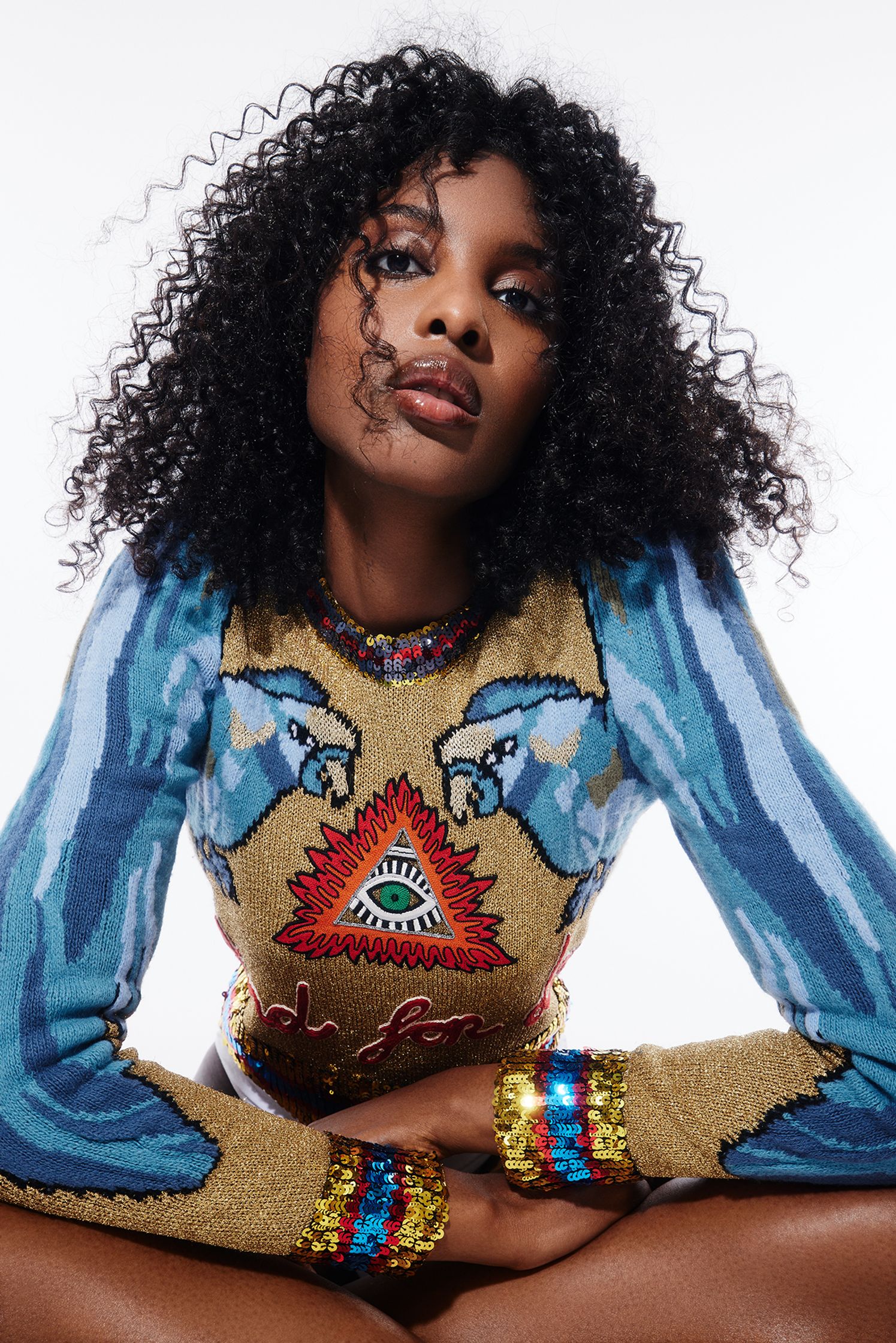 a woman with curly hair sitting on the ground