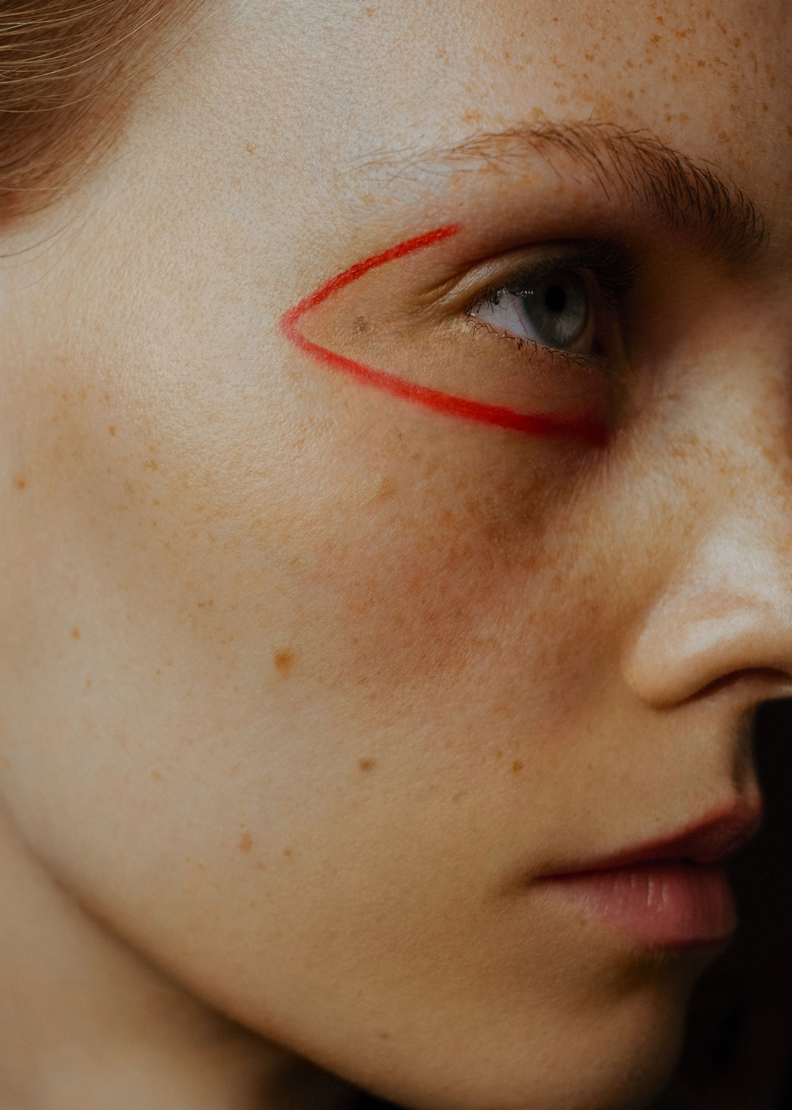 a close up of a woman with red lines on her face