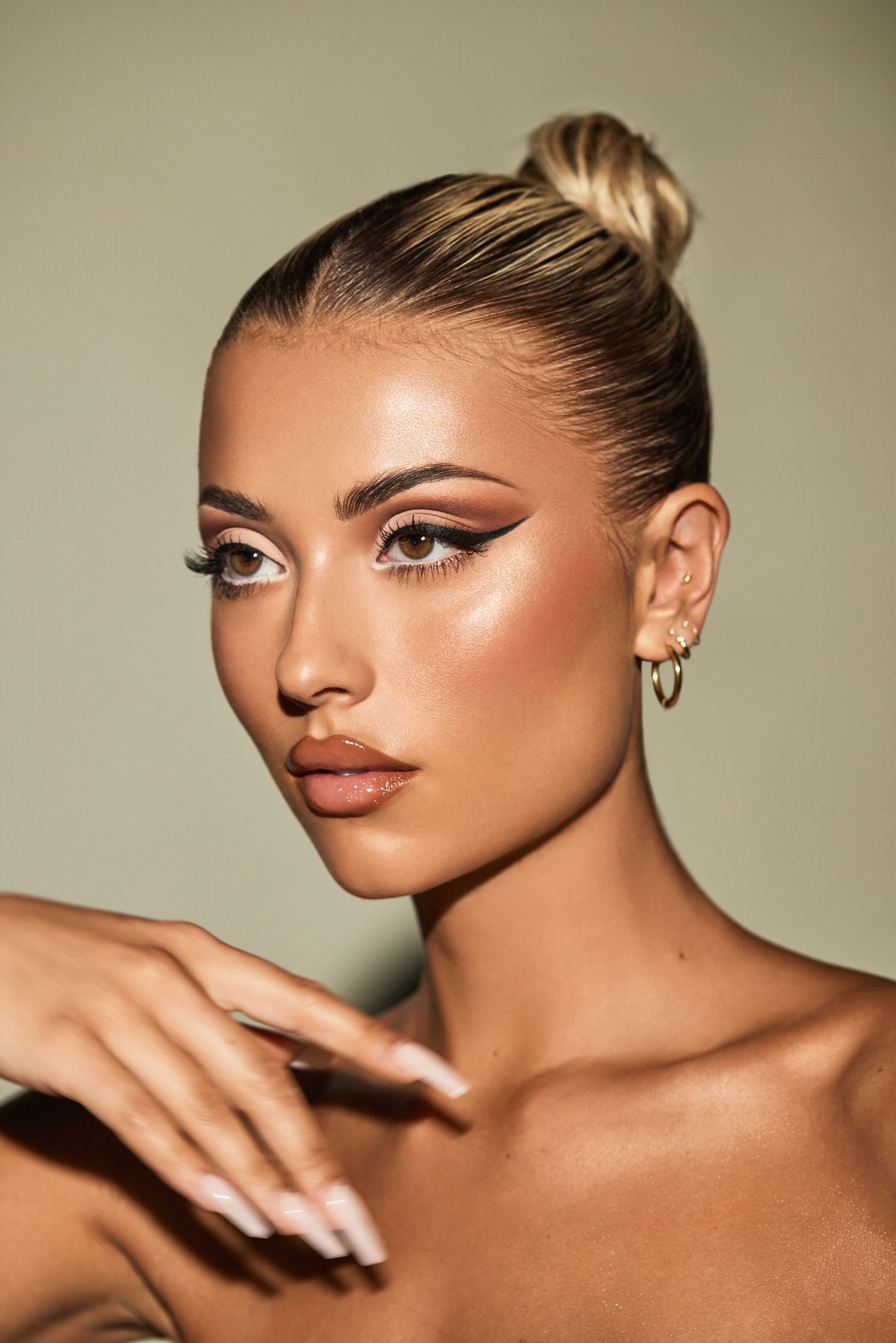 a woman with a bun and a ring on her finger