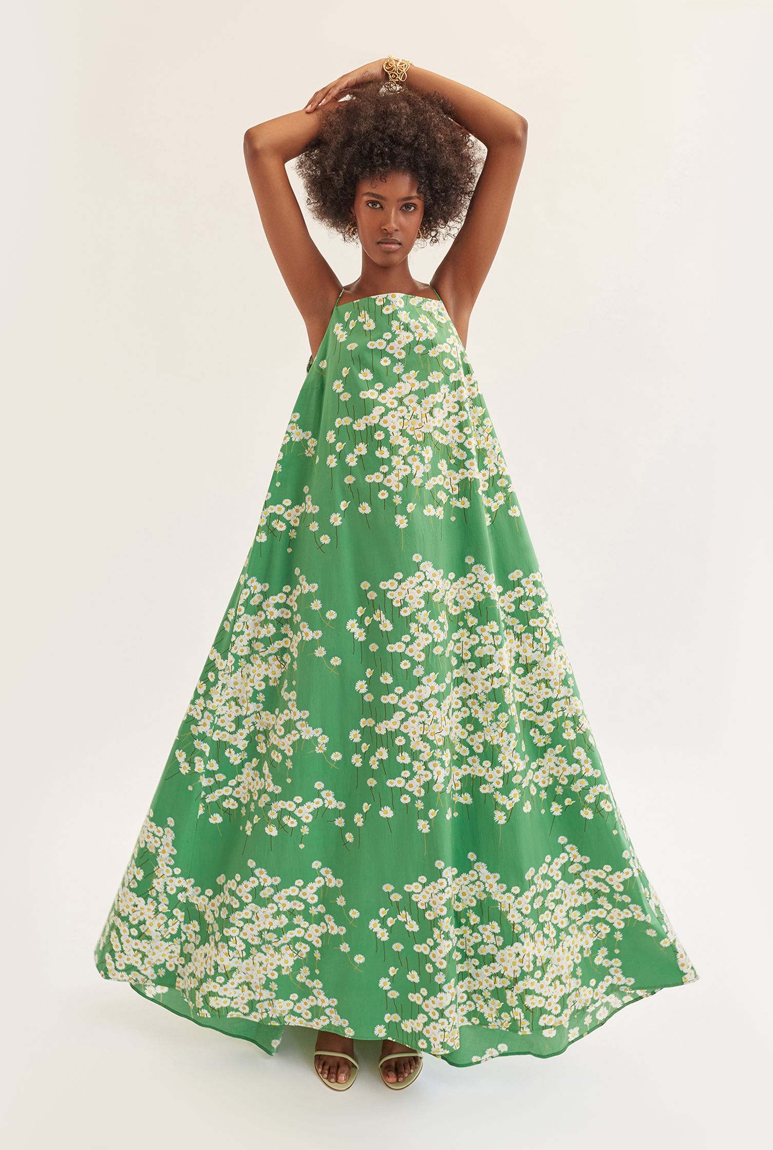 a woman wearing a green dress with white flowers on it