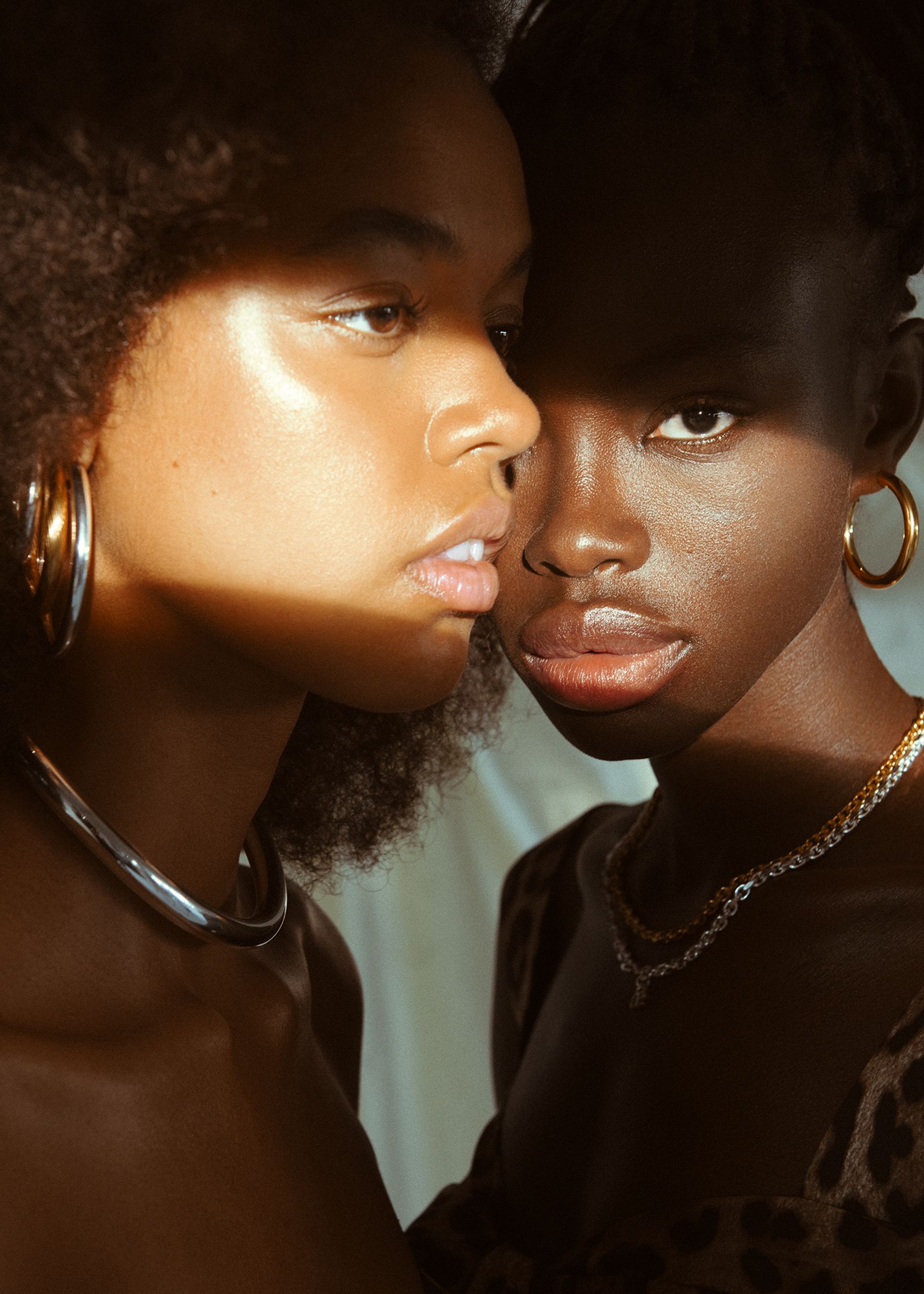two black women with afros in front of a light