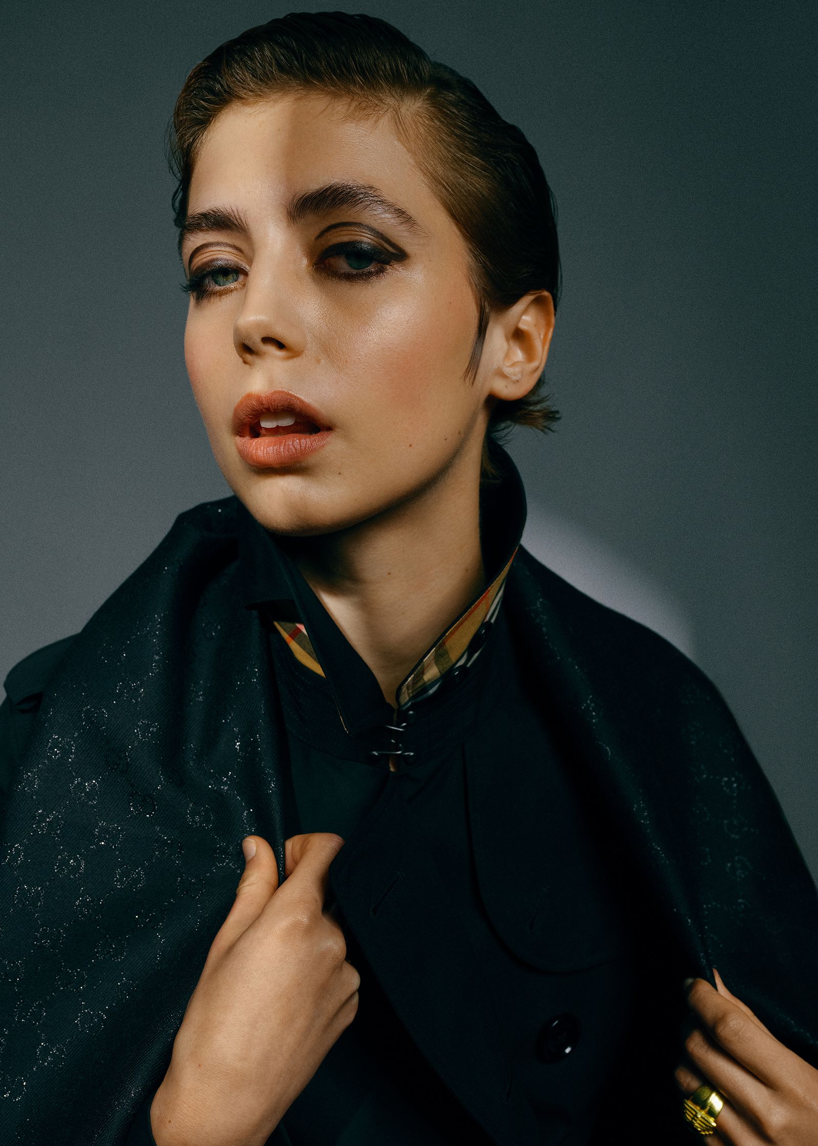 a woman in a black coat posing for a magazine