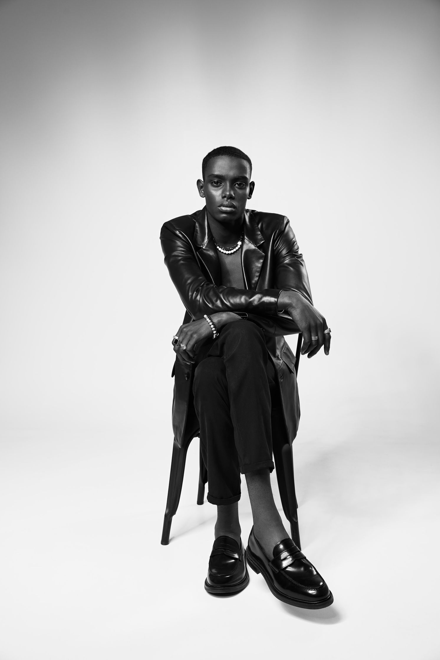 a man in a leather jacket sitting on a chair