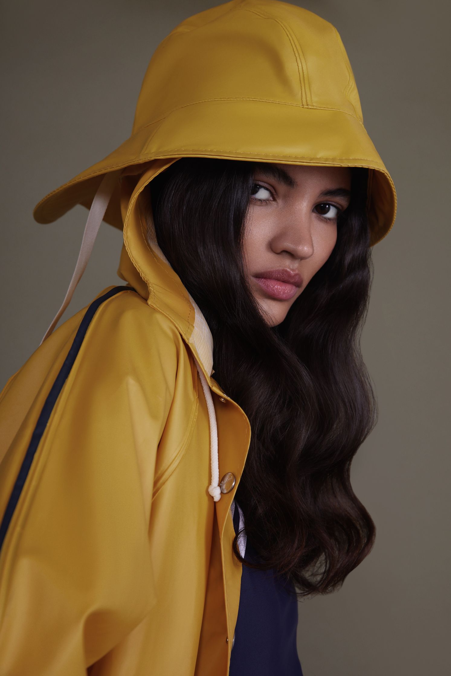 a woman in a yellow raincoat posing for a photo