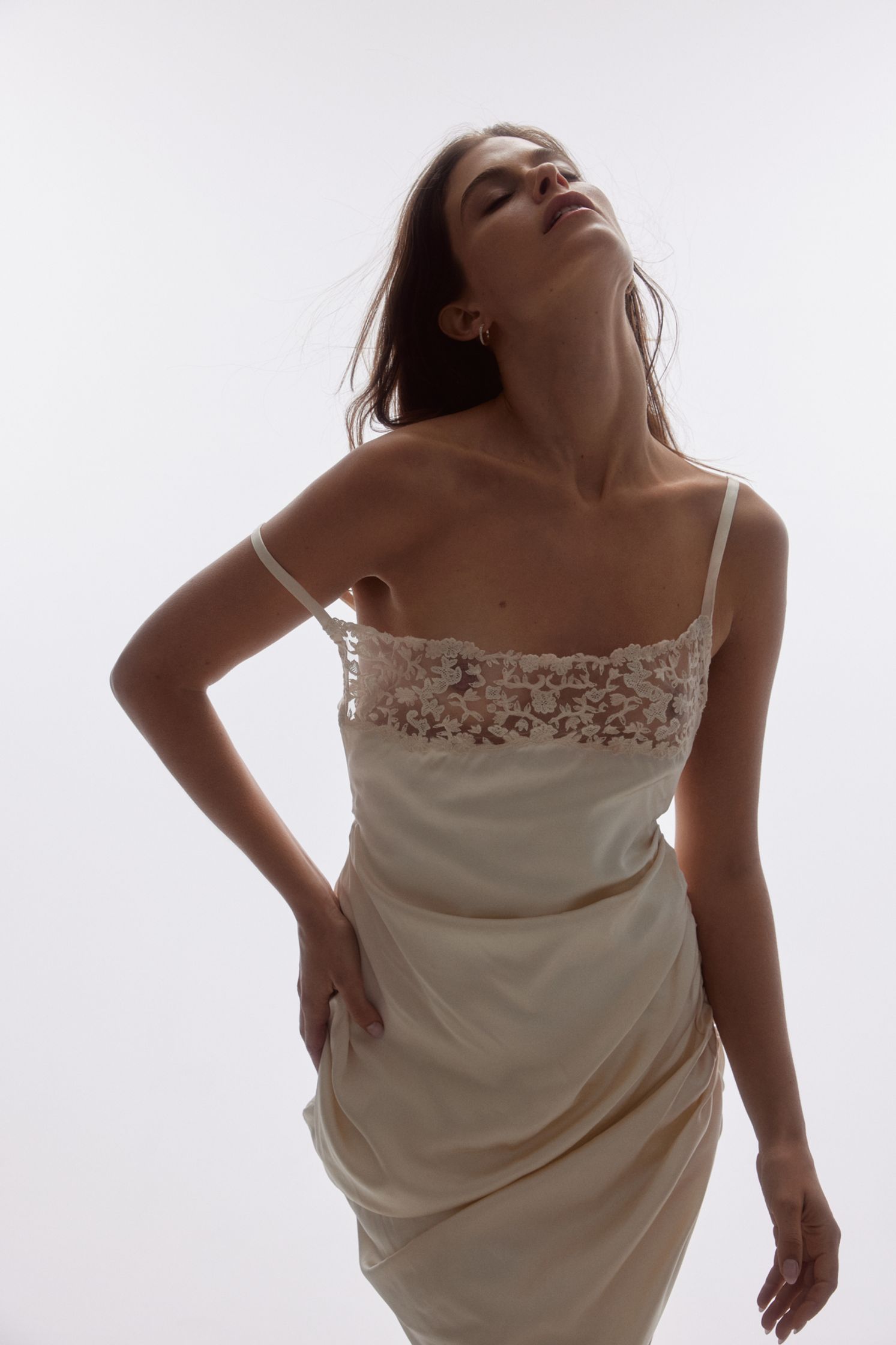 a woman in a white dress posing on a white background