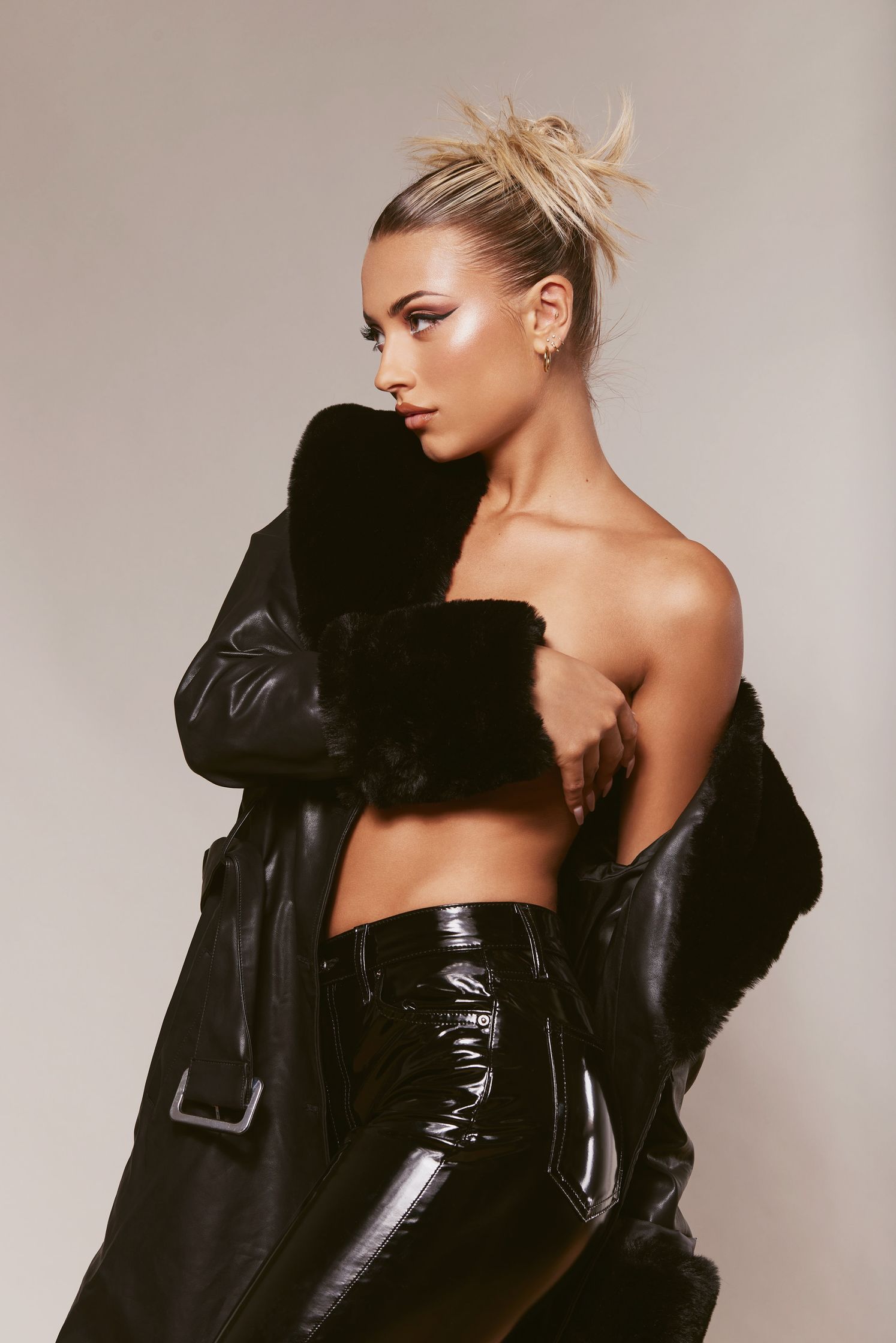a woman in black leather pants and a fur coat
