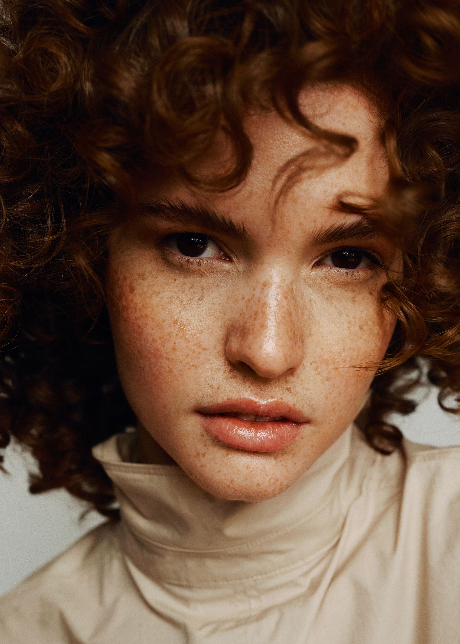 a woman with curly hair is posing for a photo