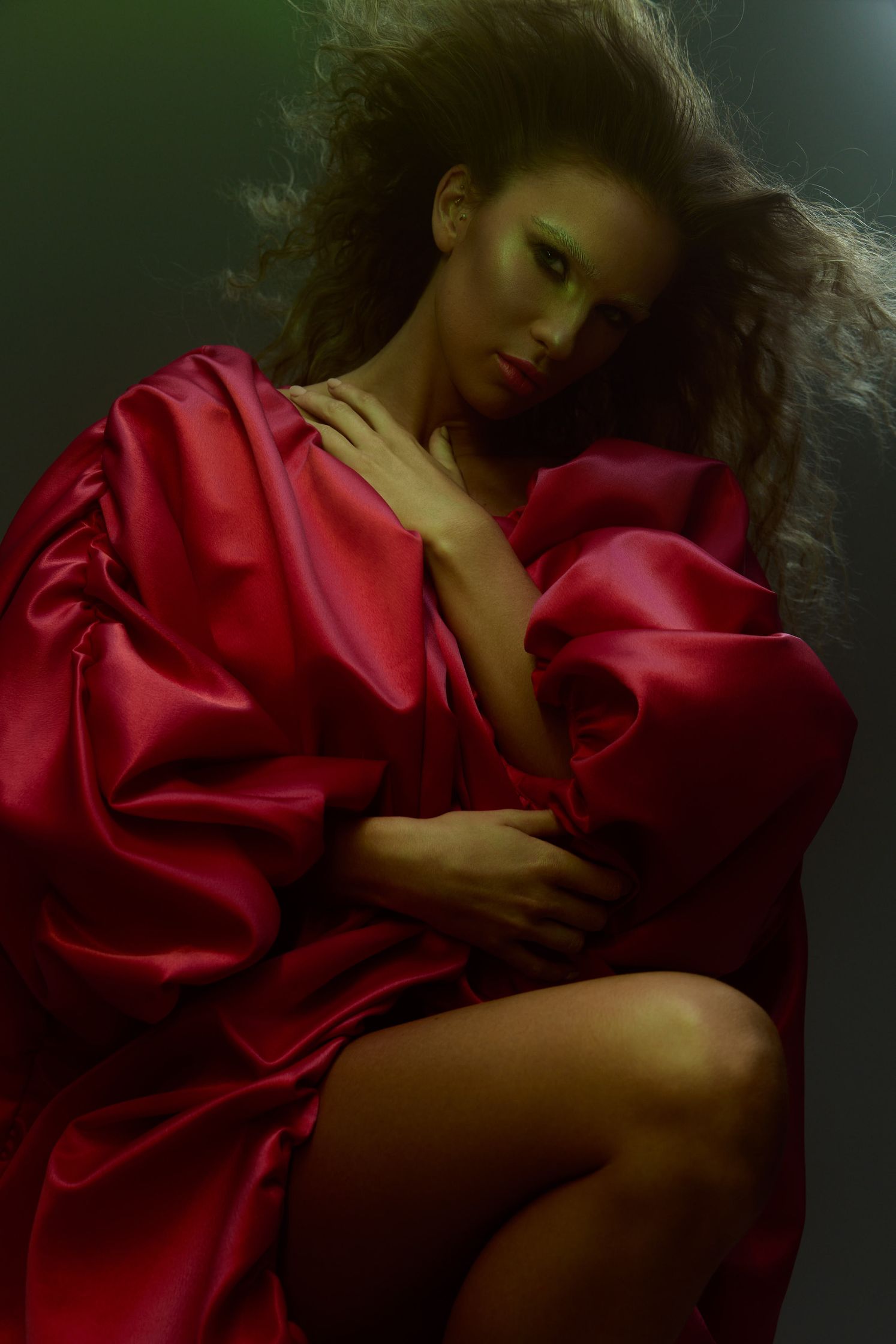 a woman in a red dress posing on a dark background