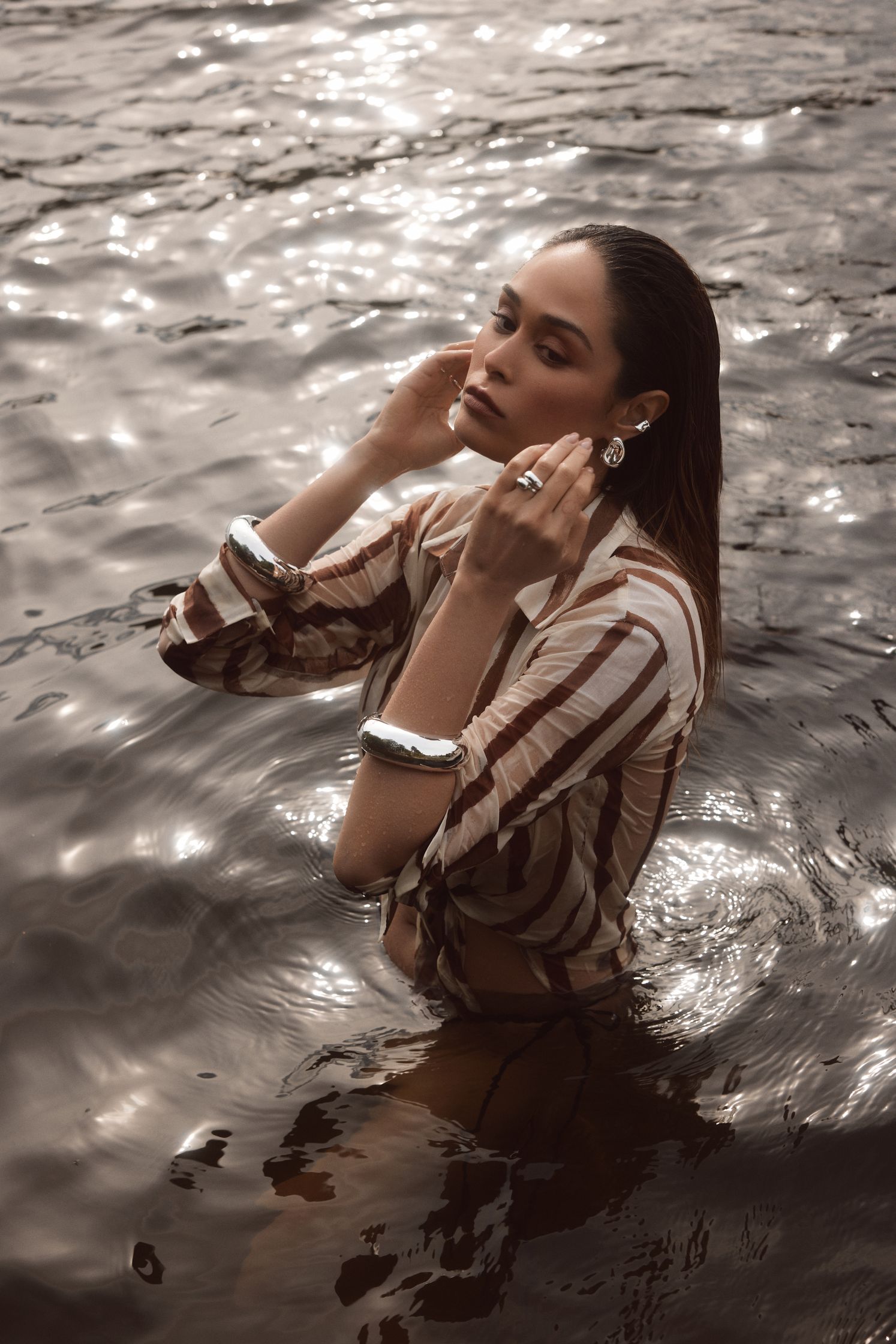 a woman in a striped shirt standing in the water