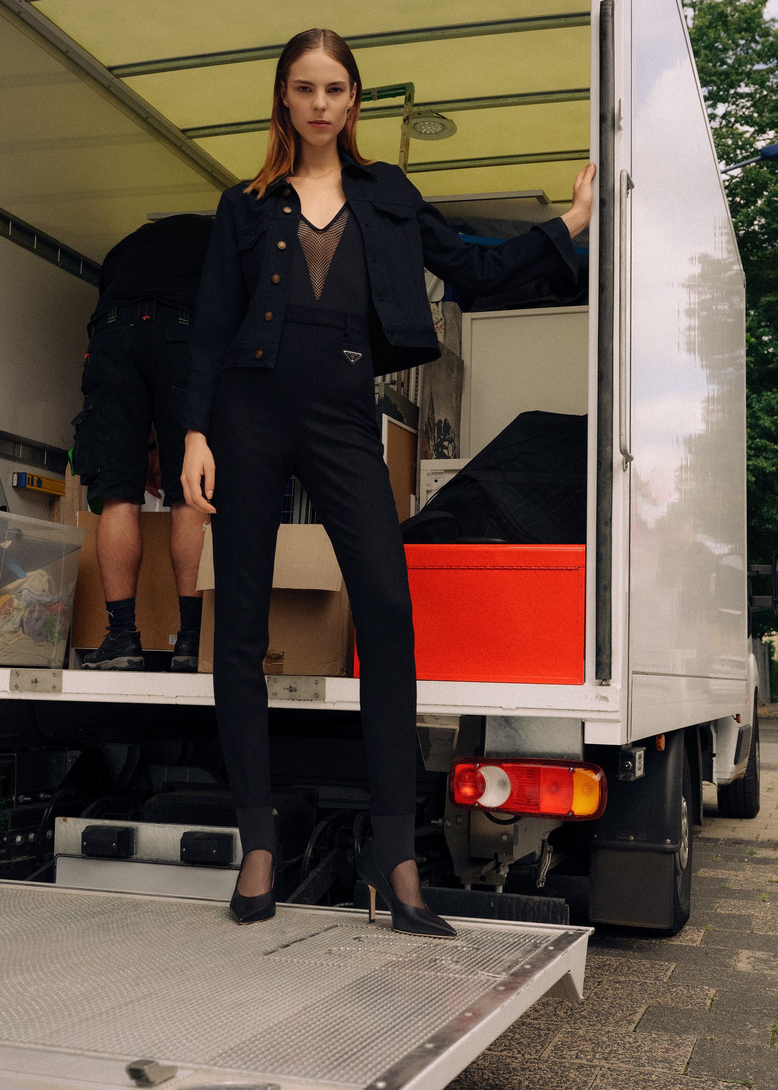 a woman standing in the back of a moving truck