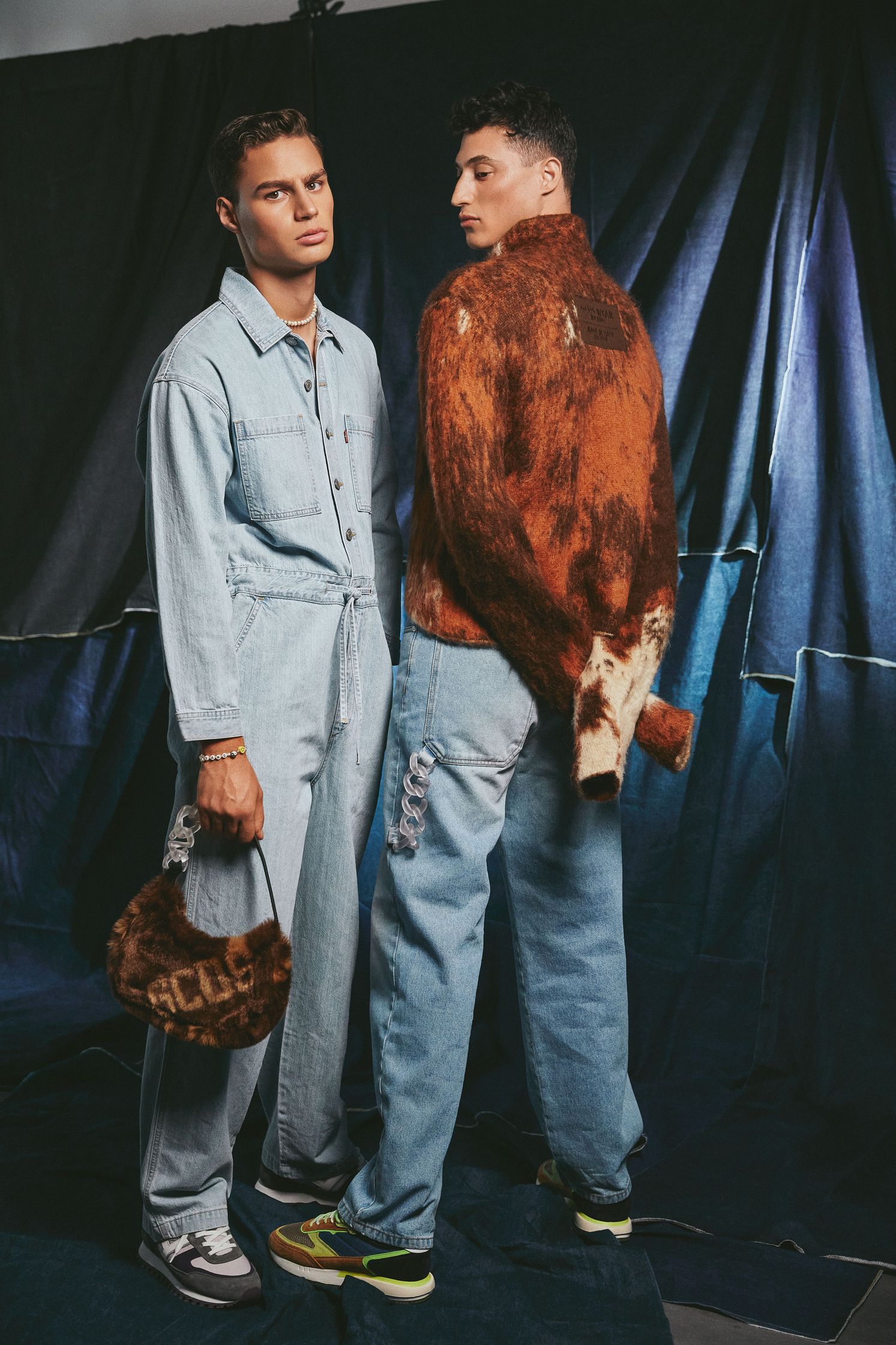 two men in denim overalls standing next to each other