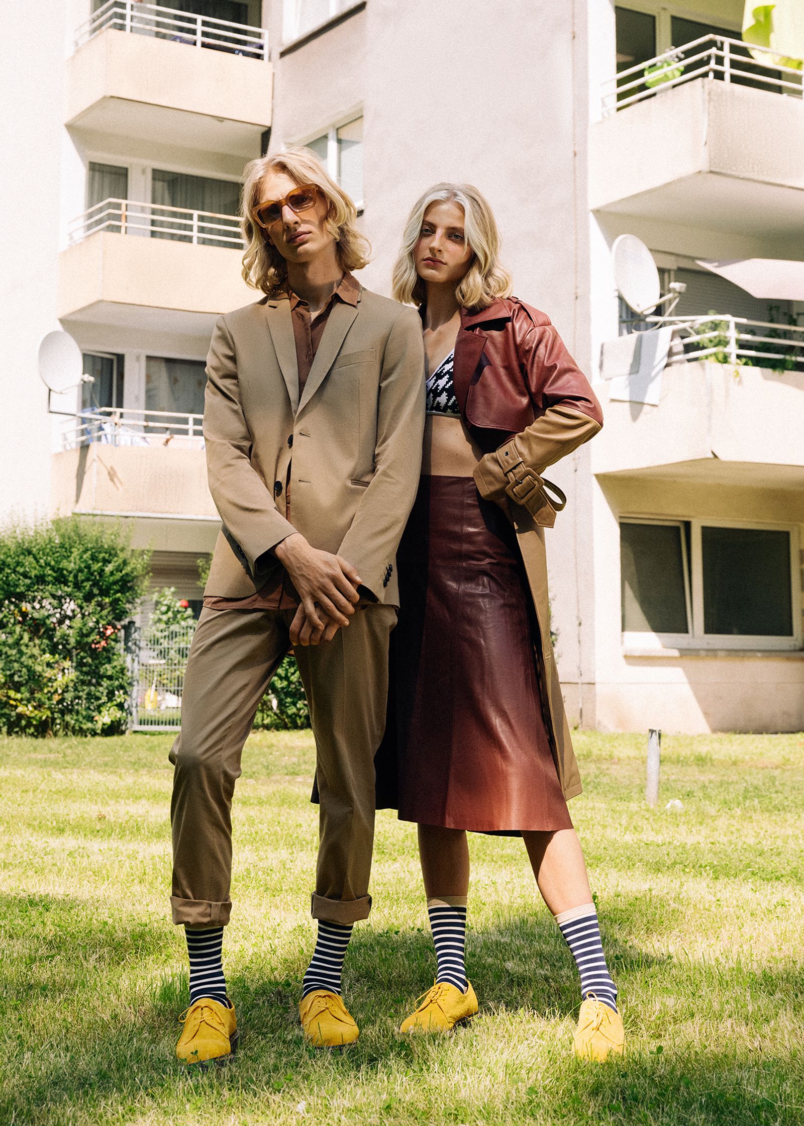 a man and woman posing in front of an apartment building