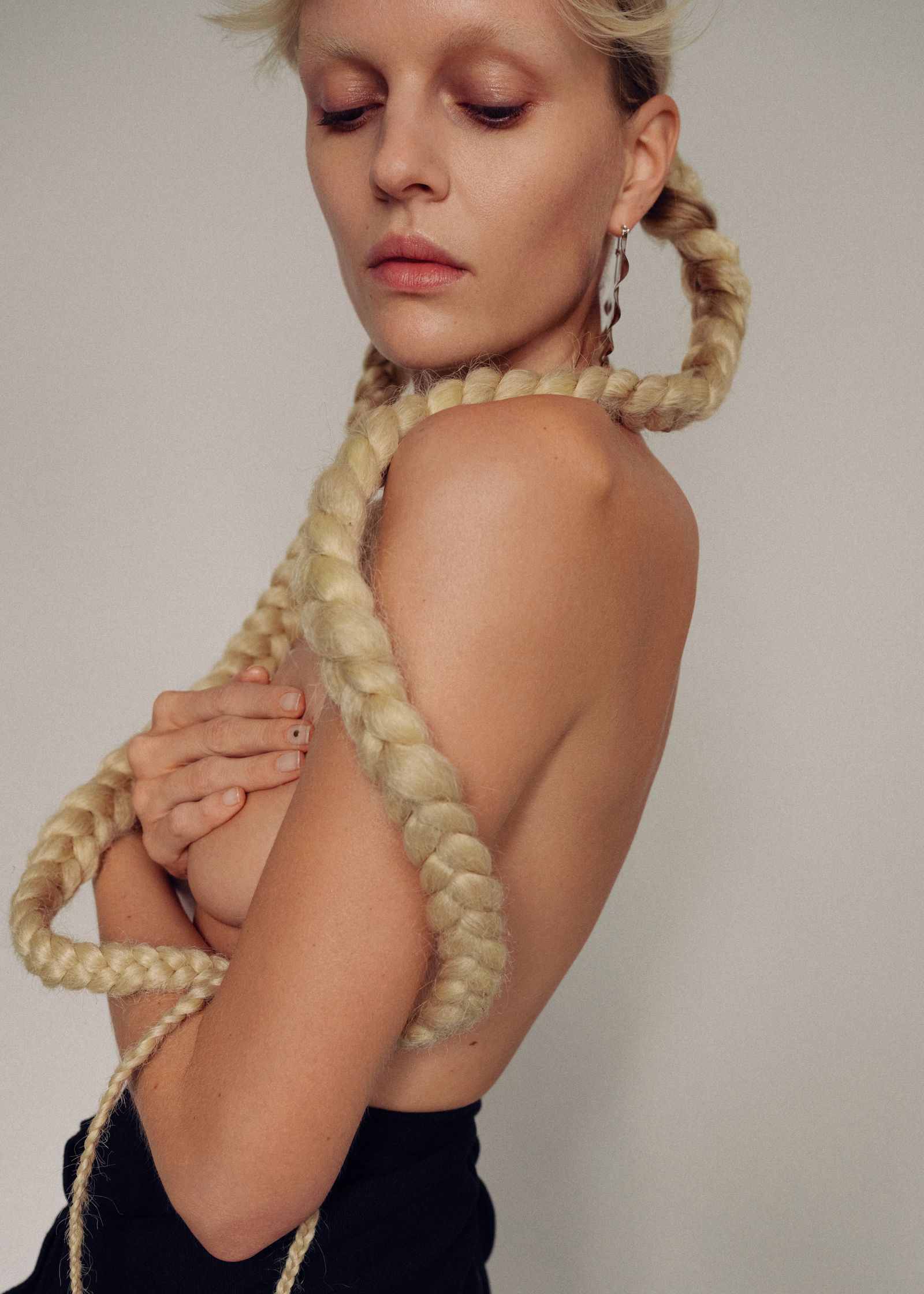 a blonde woman with braided hair posing for a magazine