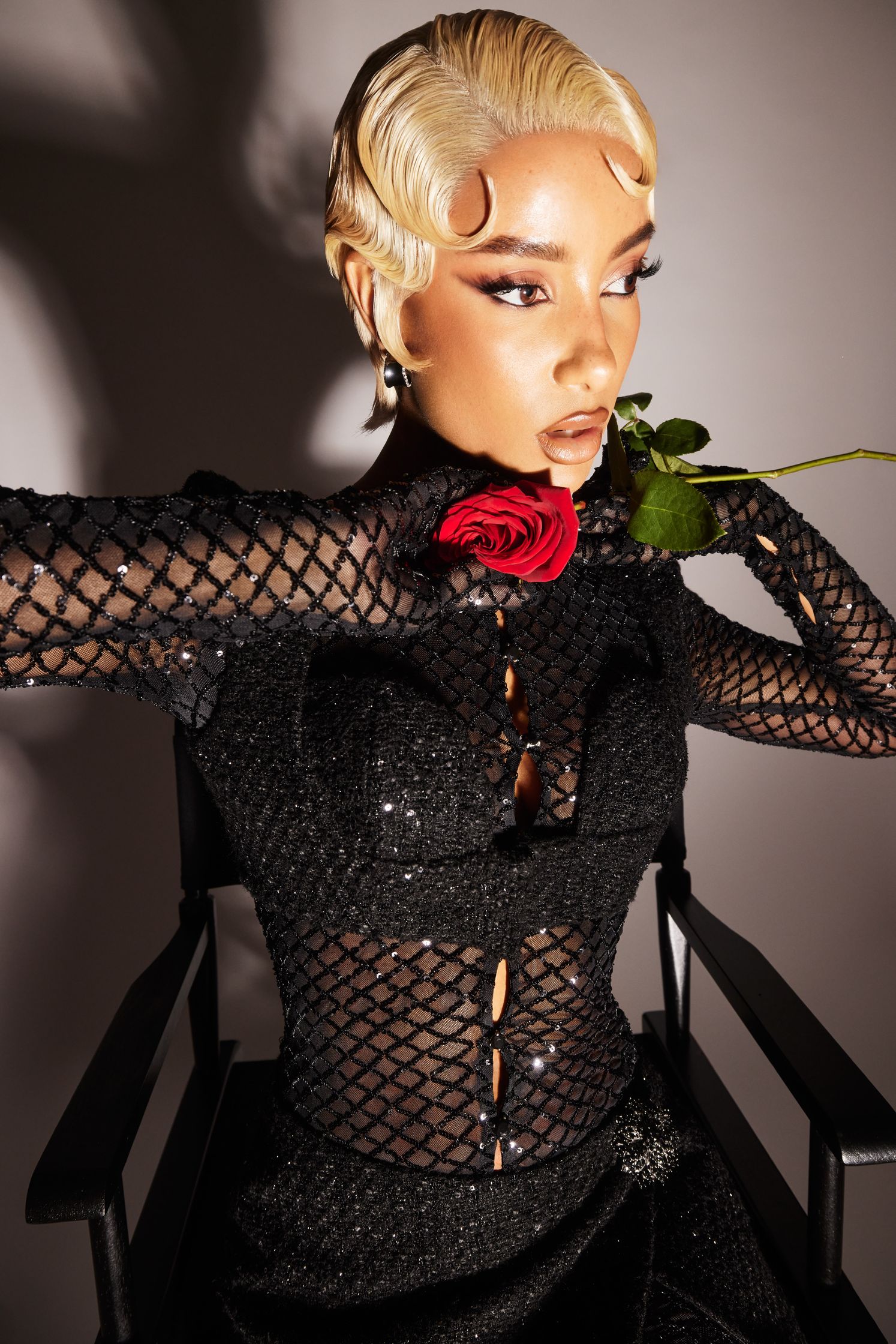 a woman in a black dress holding a rose