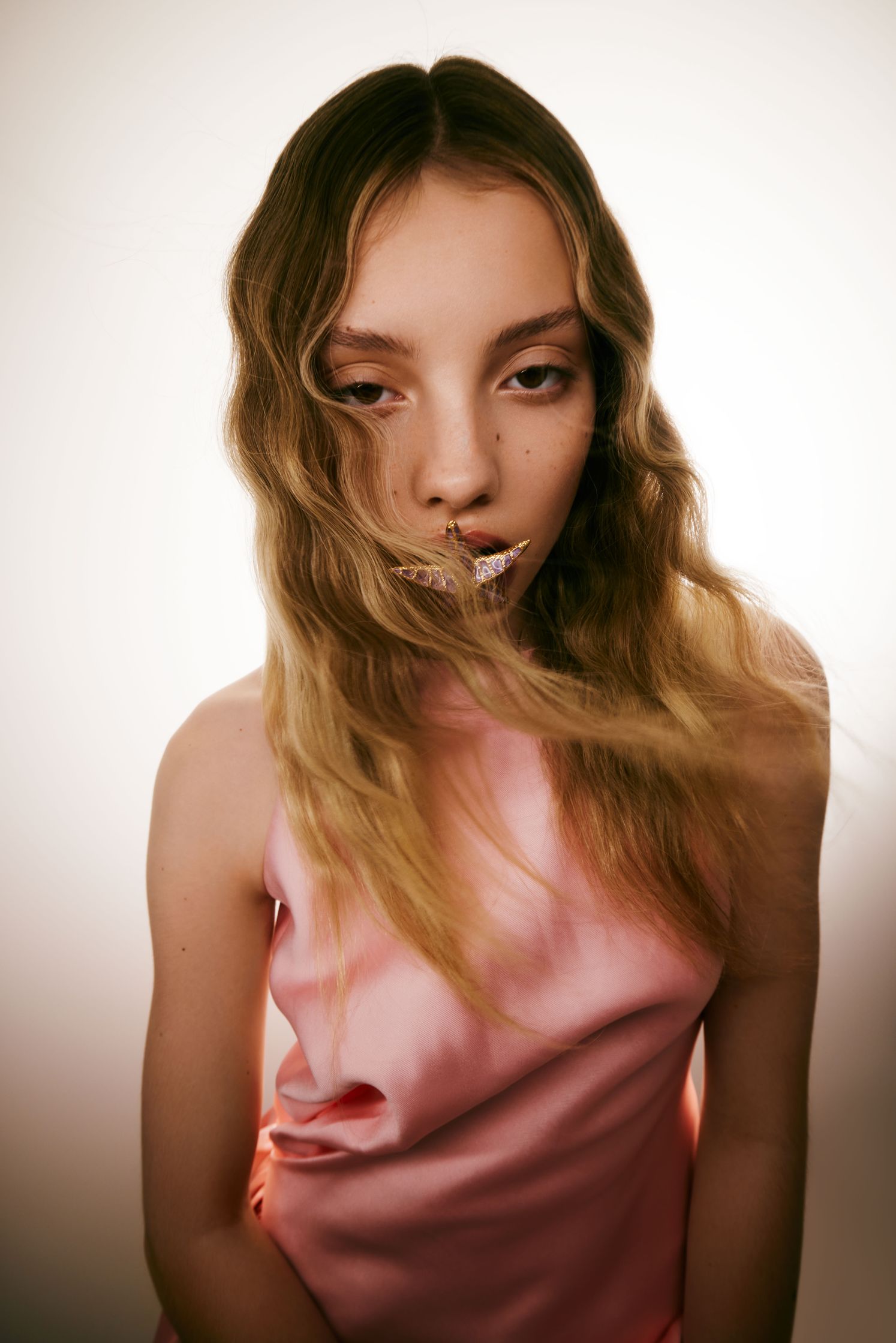 a girl in a pink dress is posing for a photo