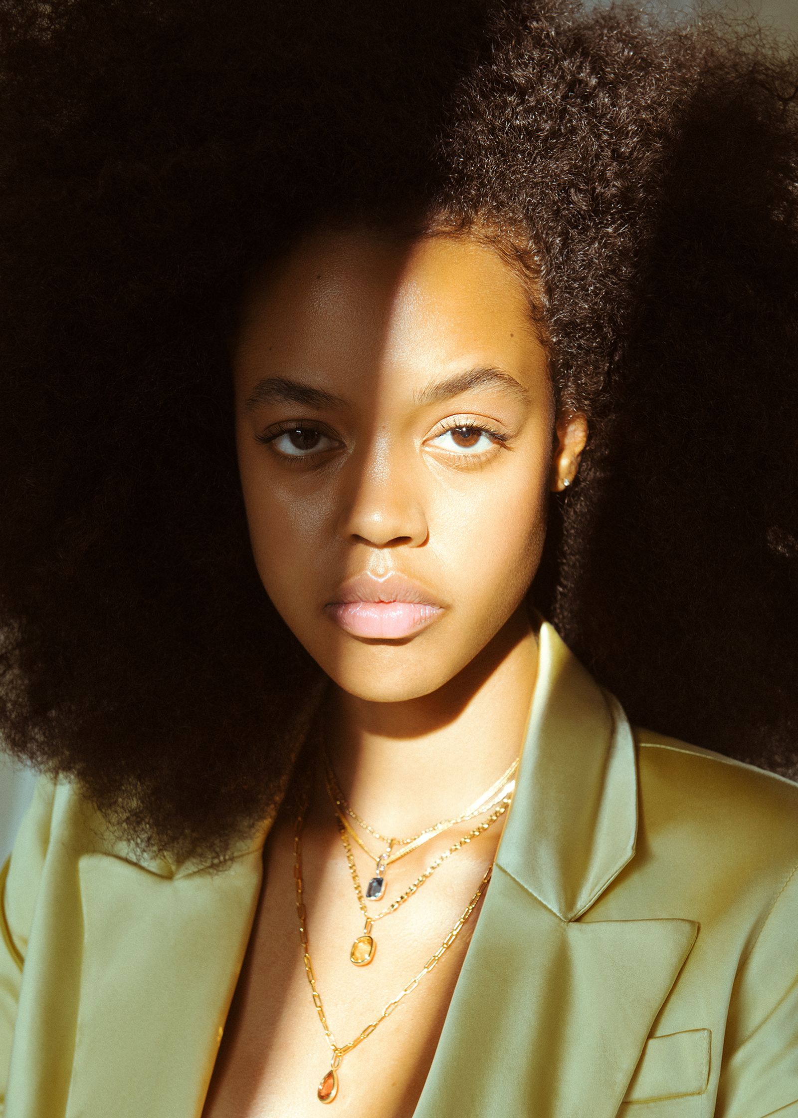 a young woman with afro hair in a green jacket