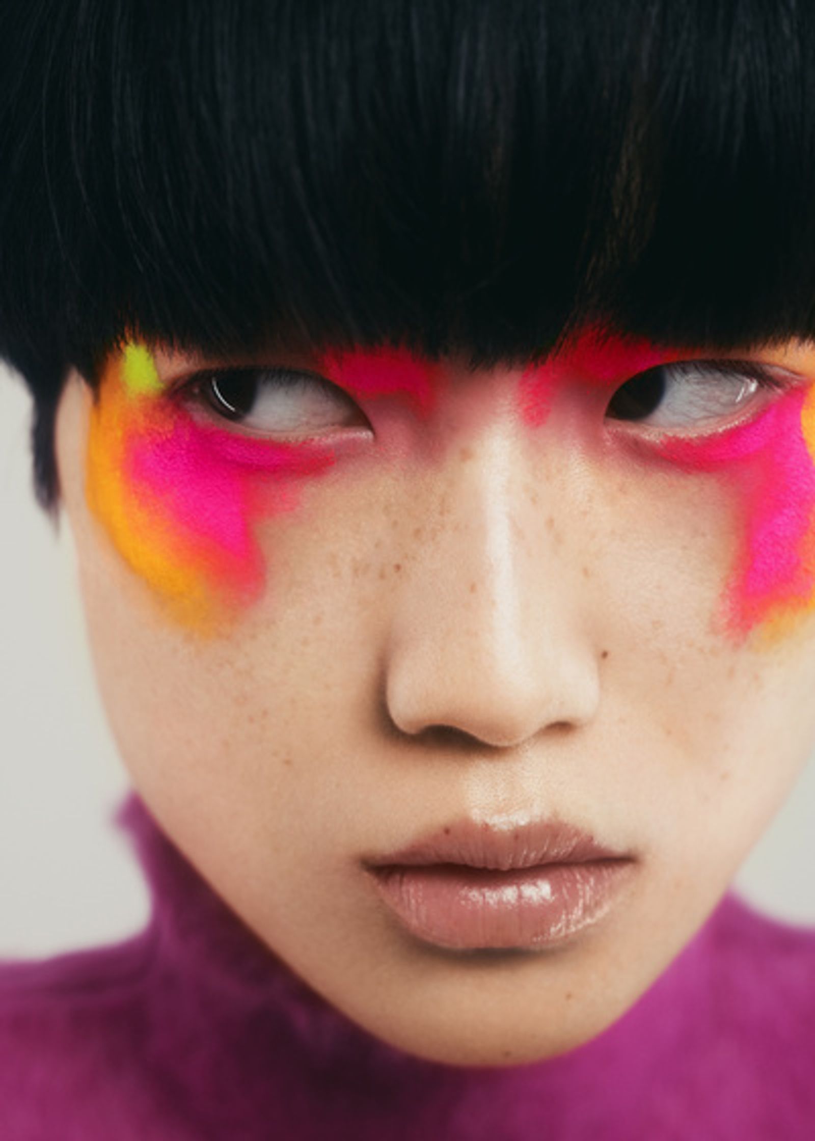 a girl with brightly colored makeup on her face