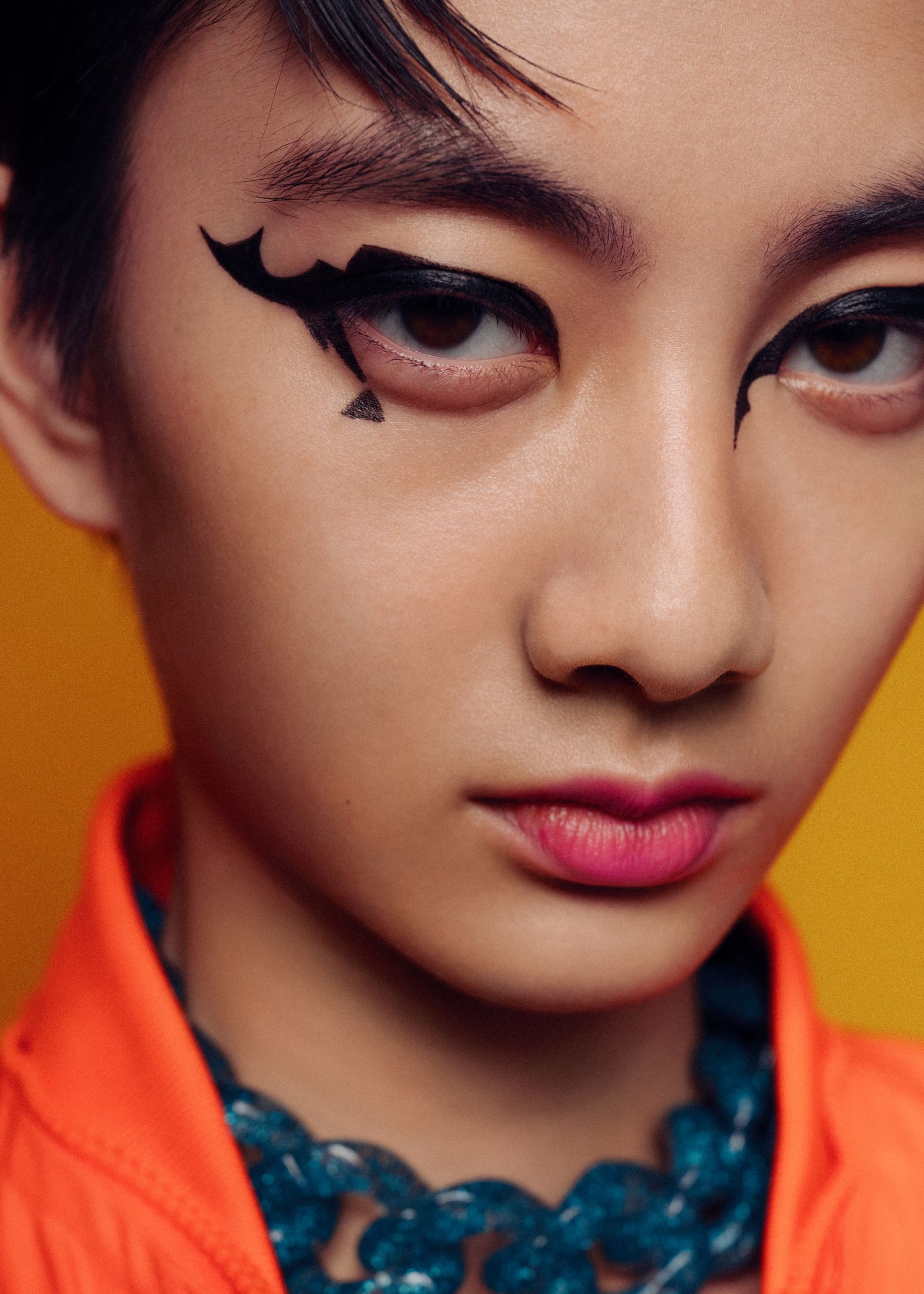 a young asian girl with black eyeliner on her face