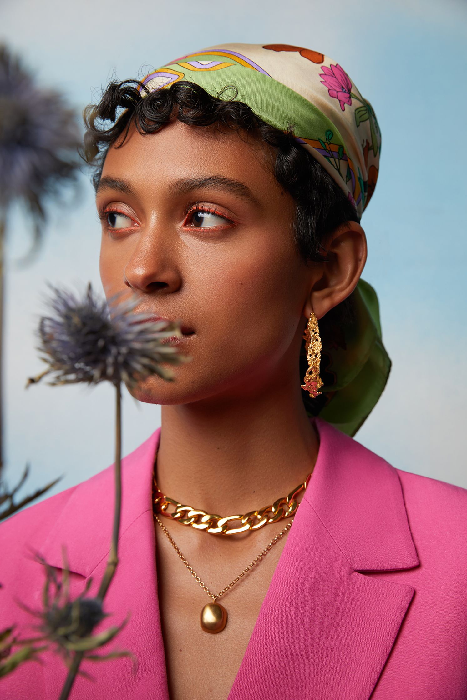 a woman in a pink jacket with a flower in her hand