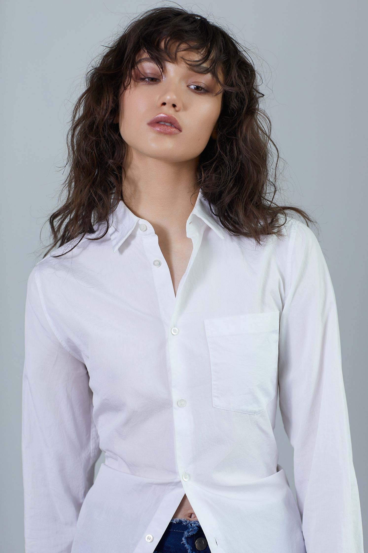 a woman wearing a white shirt and jeans