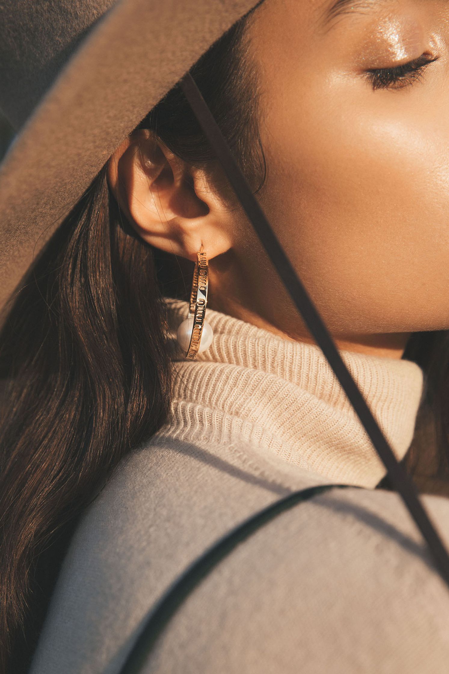 a woman wearing a hat and earrings