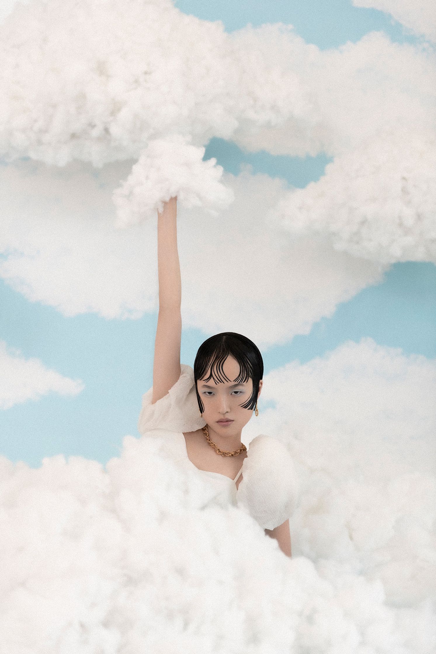 a woman in a white dress surrounded by clouds