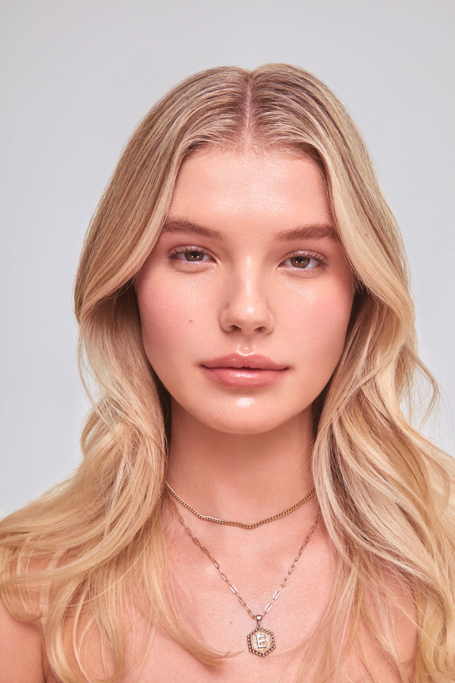 a woman with long blonde hair and a necklace