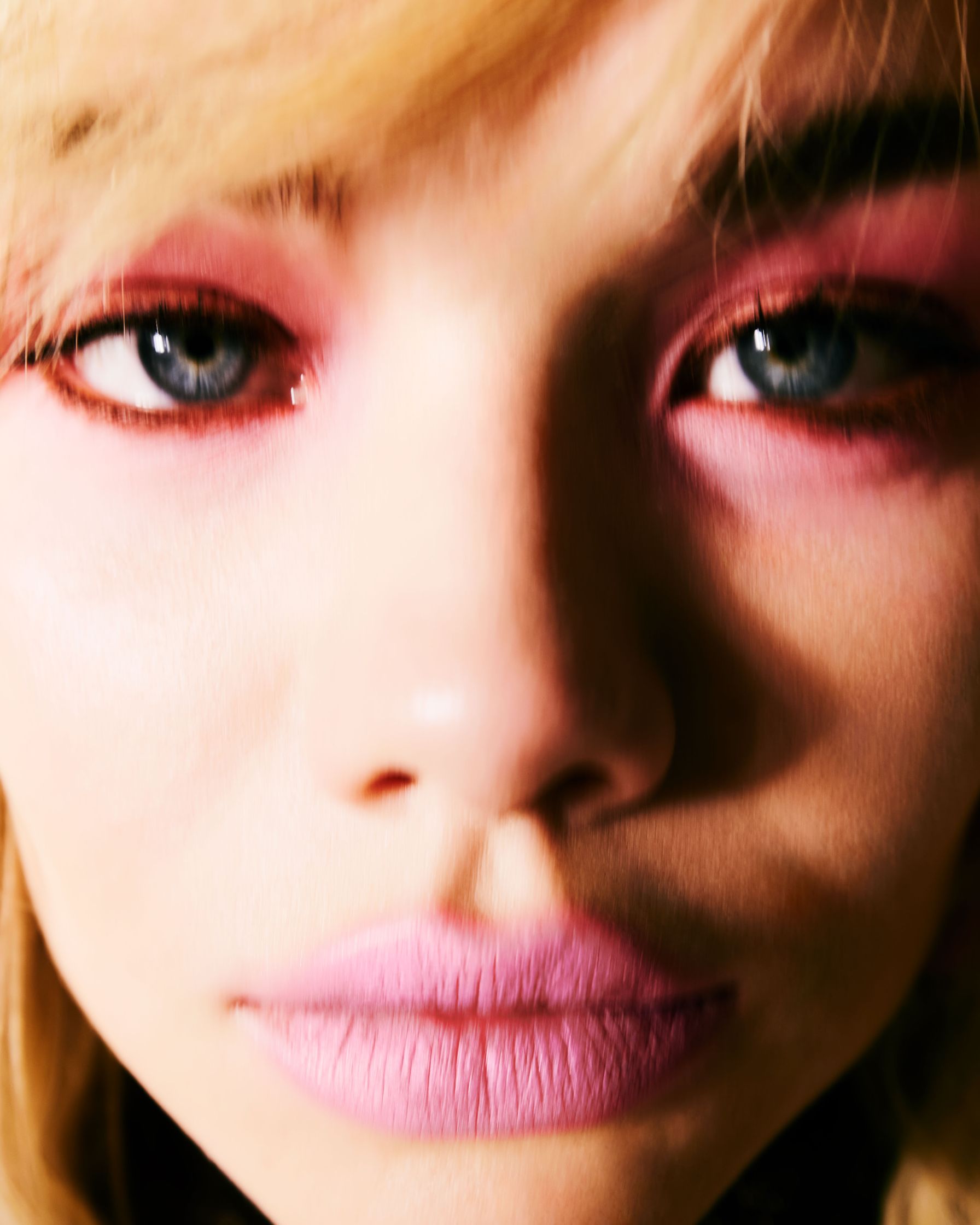 a close up of a woman with pink eyes