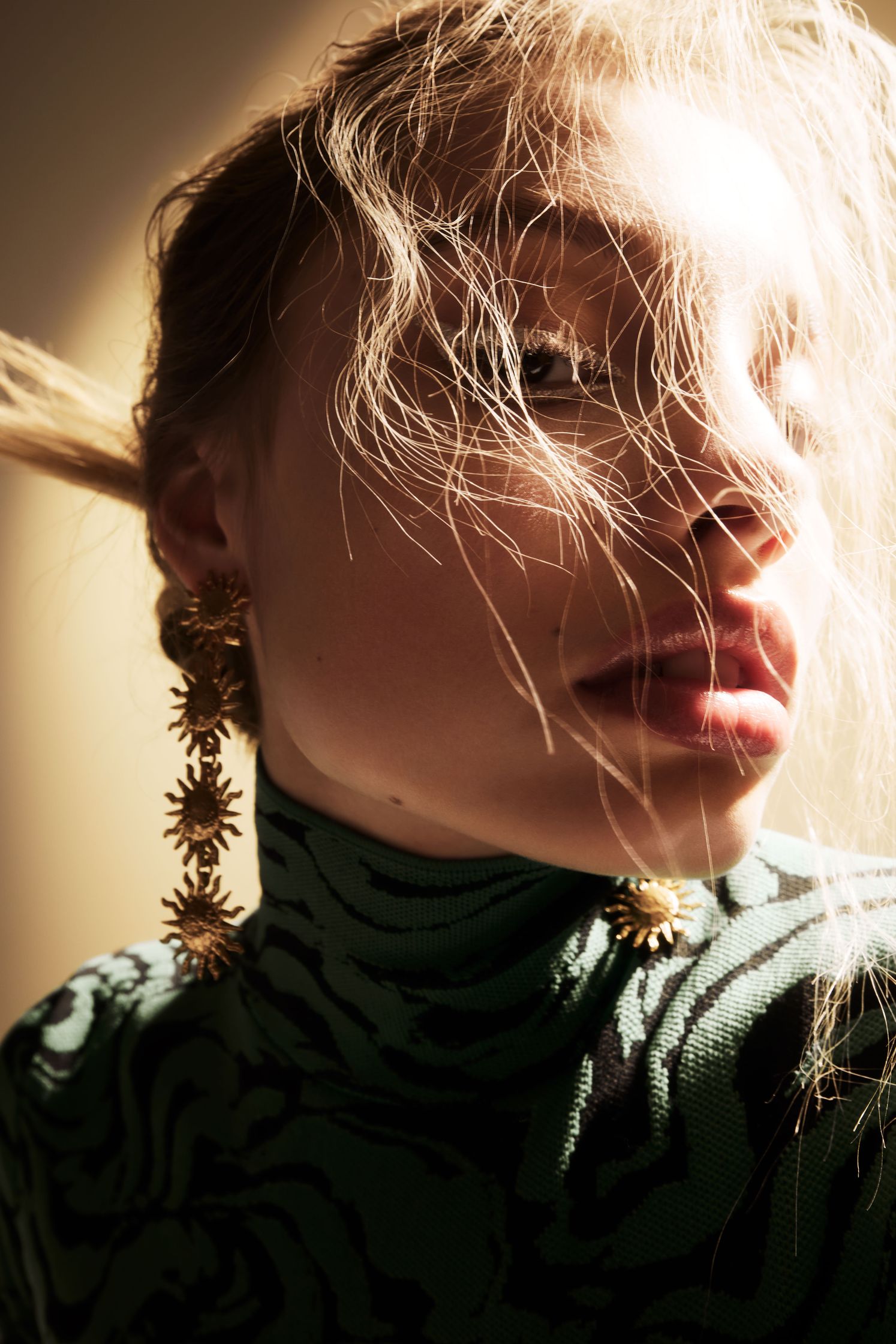 a woman wearing a zebra print top and gold earrings