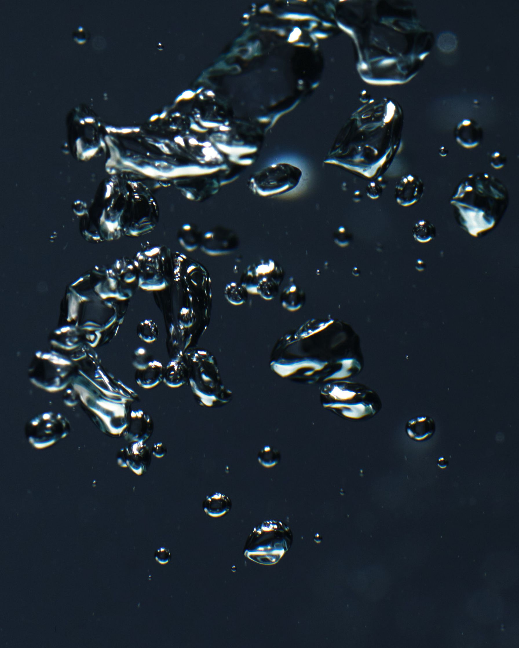 Close-up of bubbles rising underwater, creating abstract shapes and light refraction.