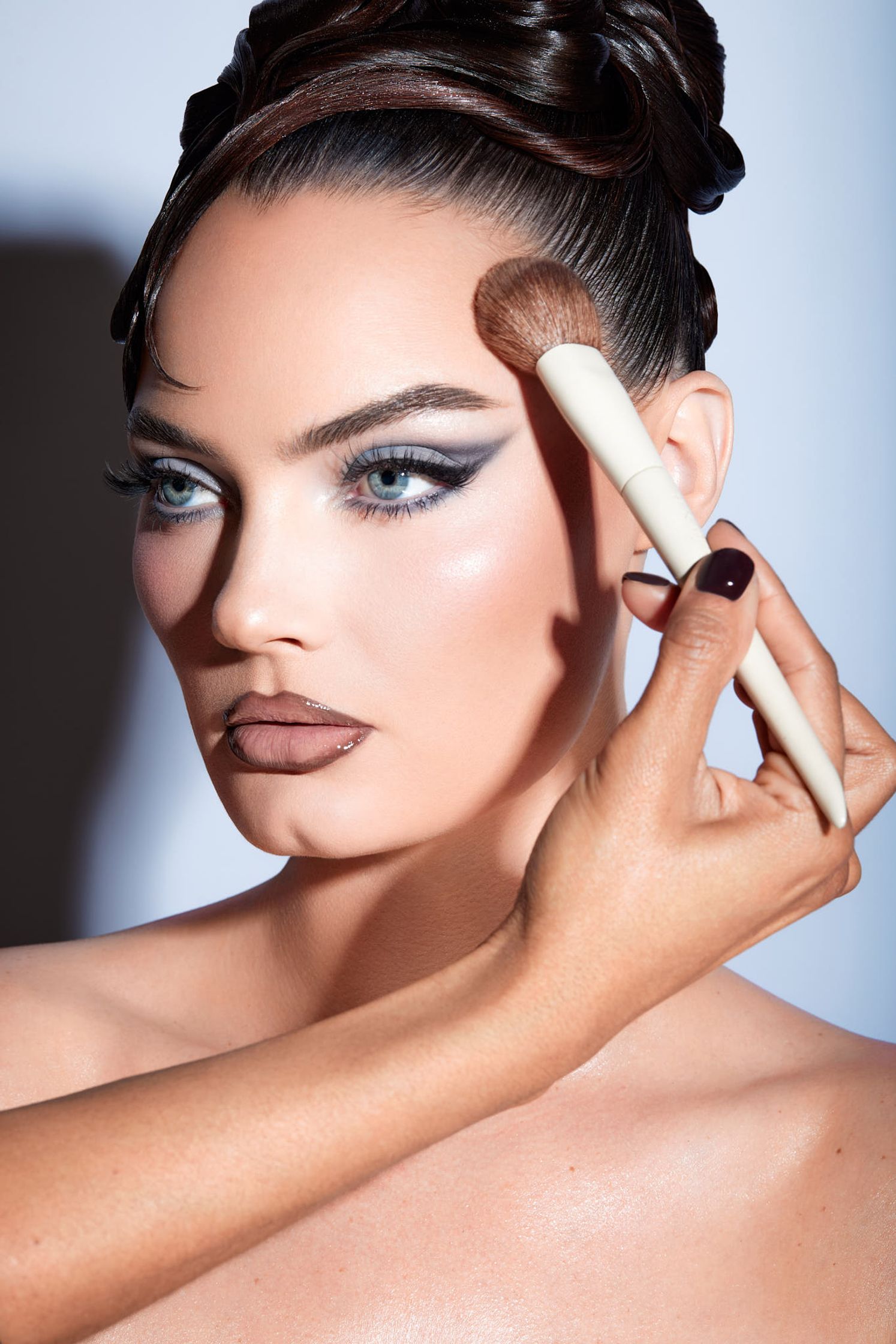 a woman is applying makeup with a brush