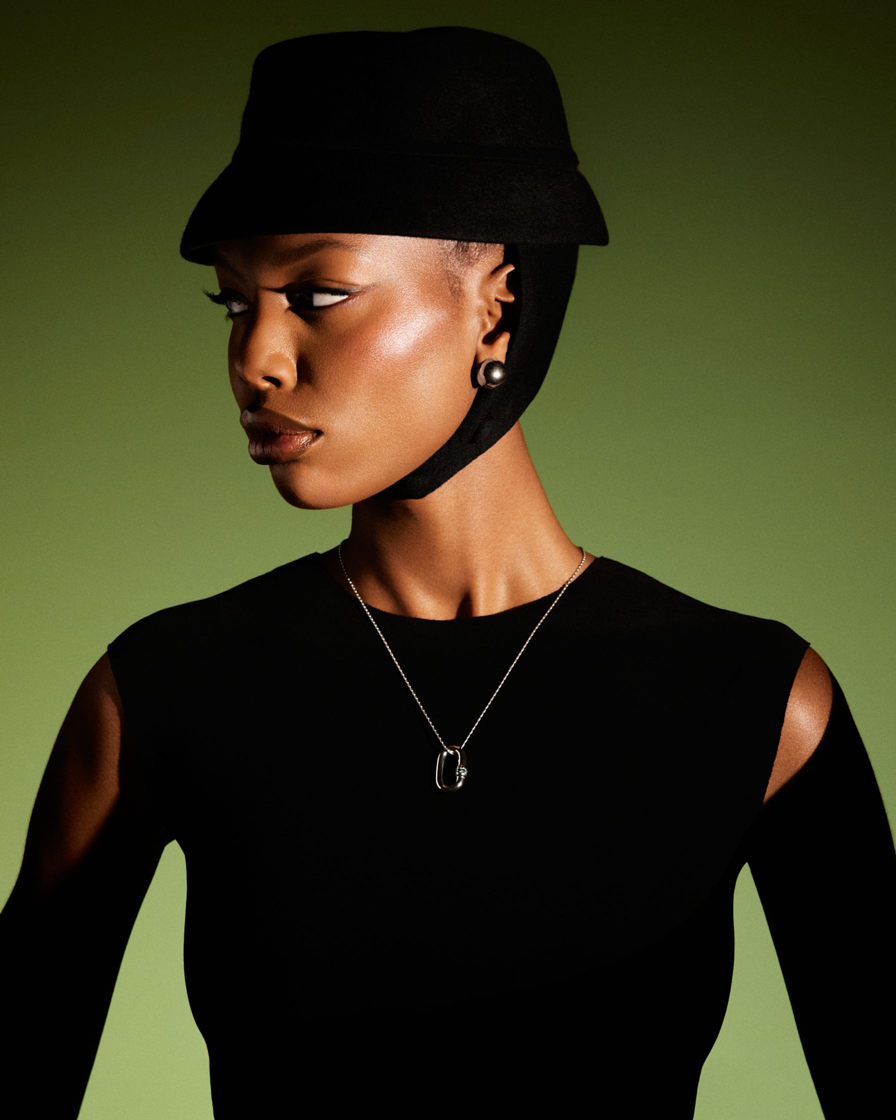 a black woman wearing a hat and necklace