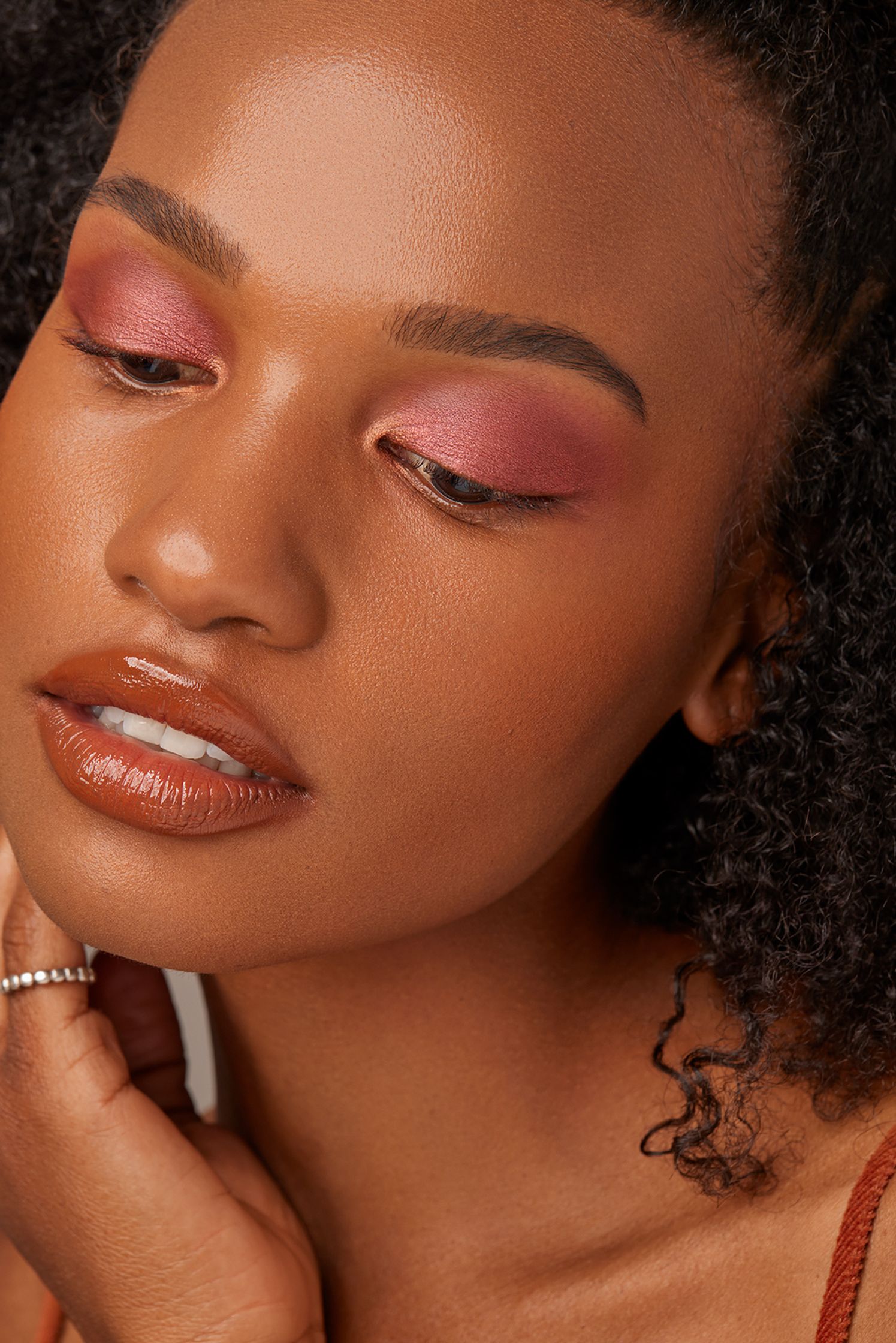a black woman with curly hair and pink eyeshadow