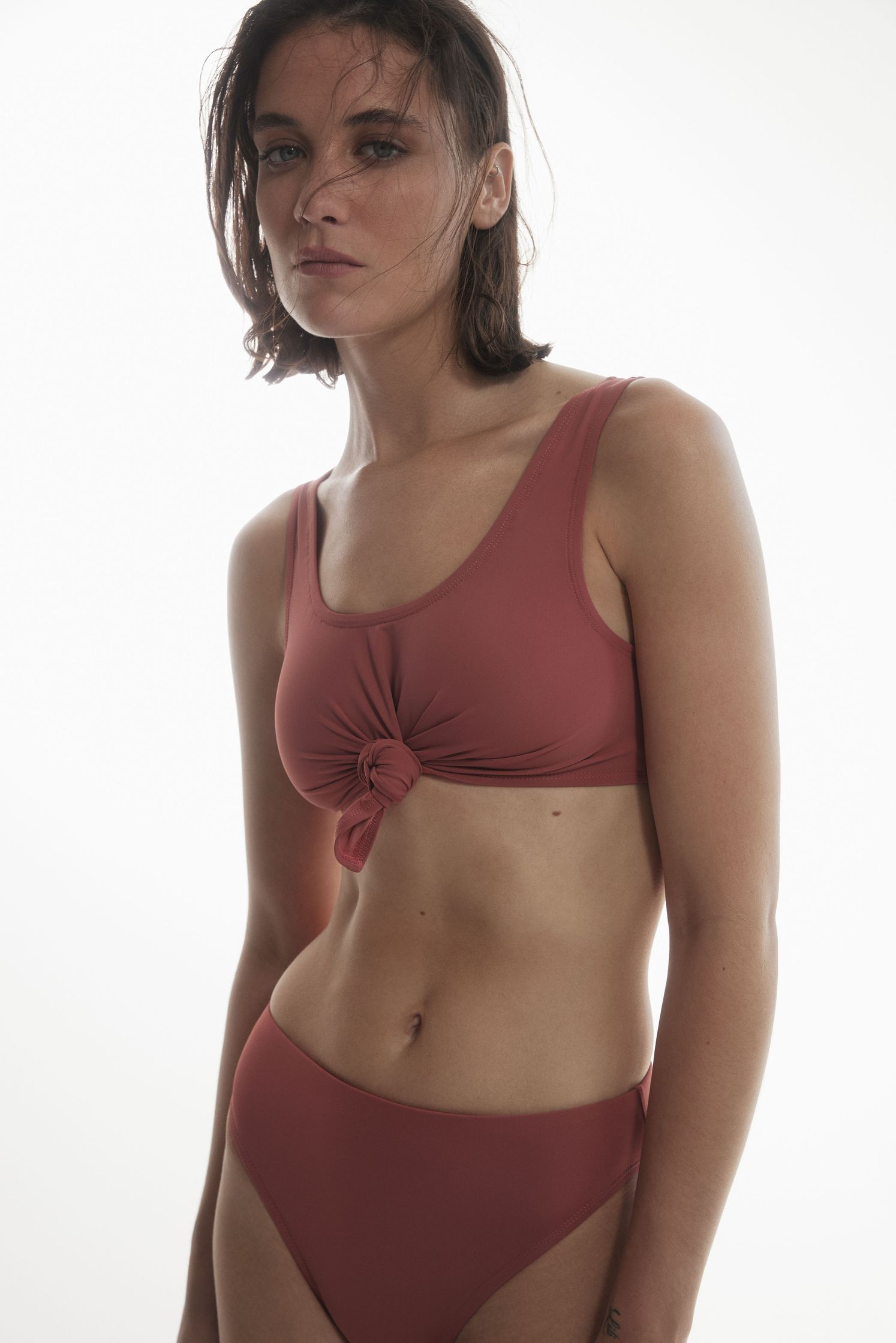 a woman in a red bikini top posing for a photo