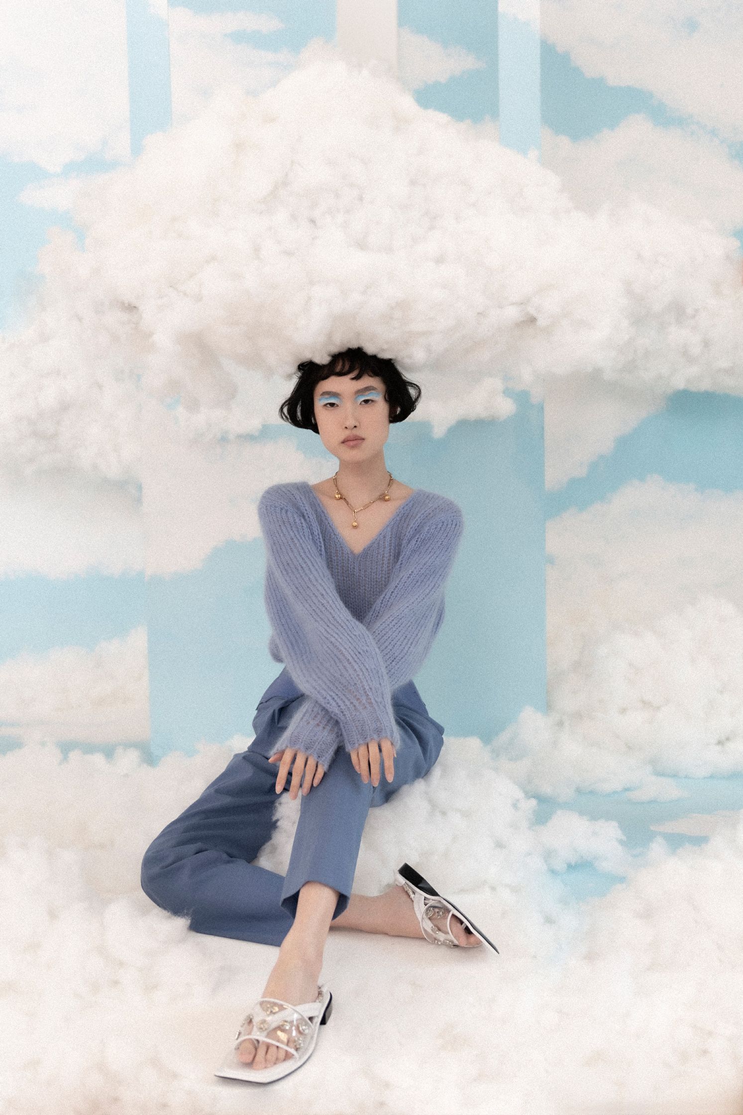 a woman sitting on top of a cloud