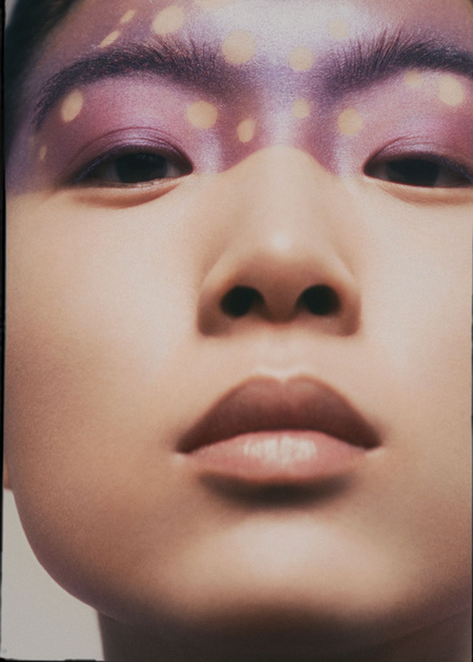 an asian woman with purple makeup on her face