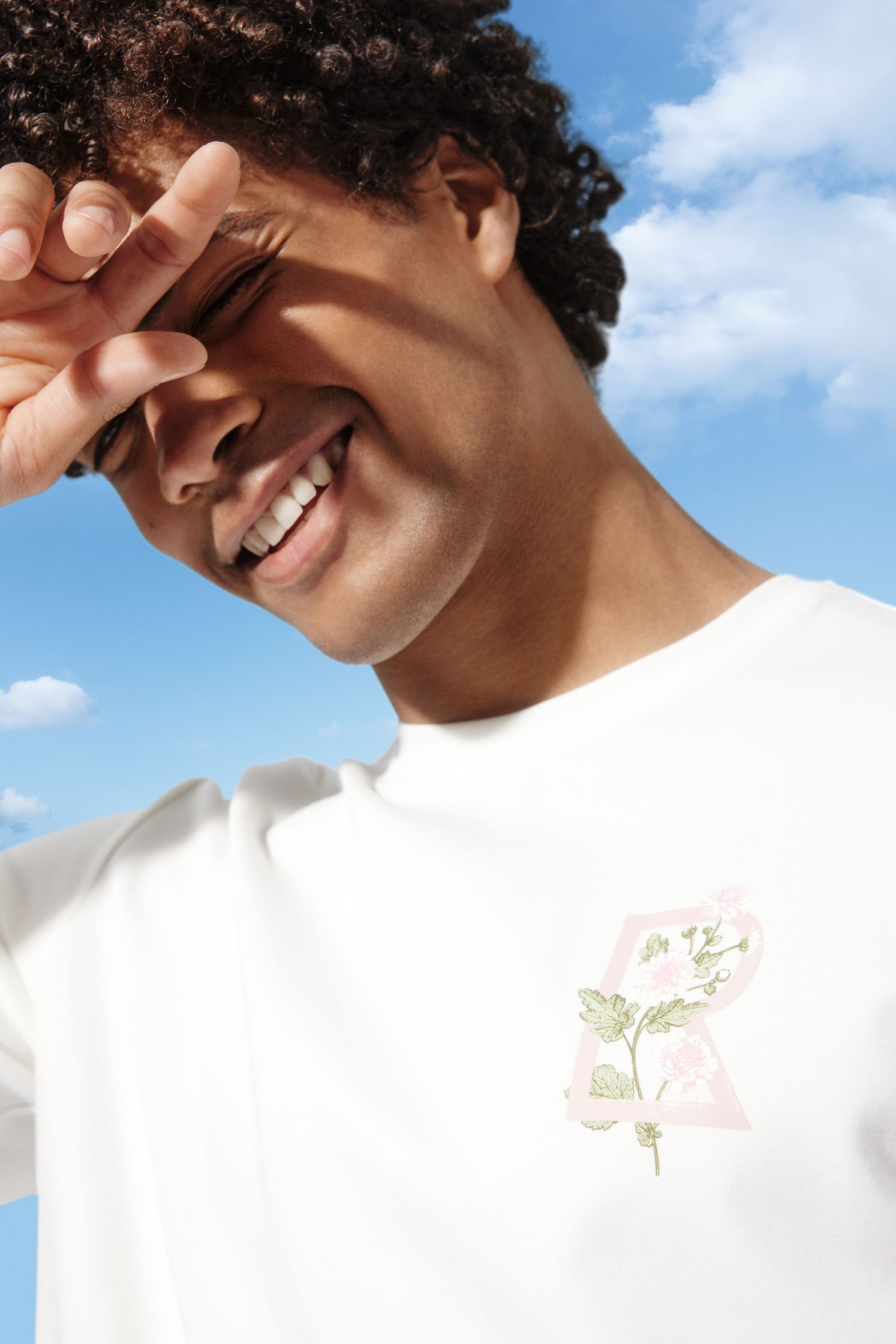 a man wearing a white t - shirt with a flower on it