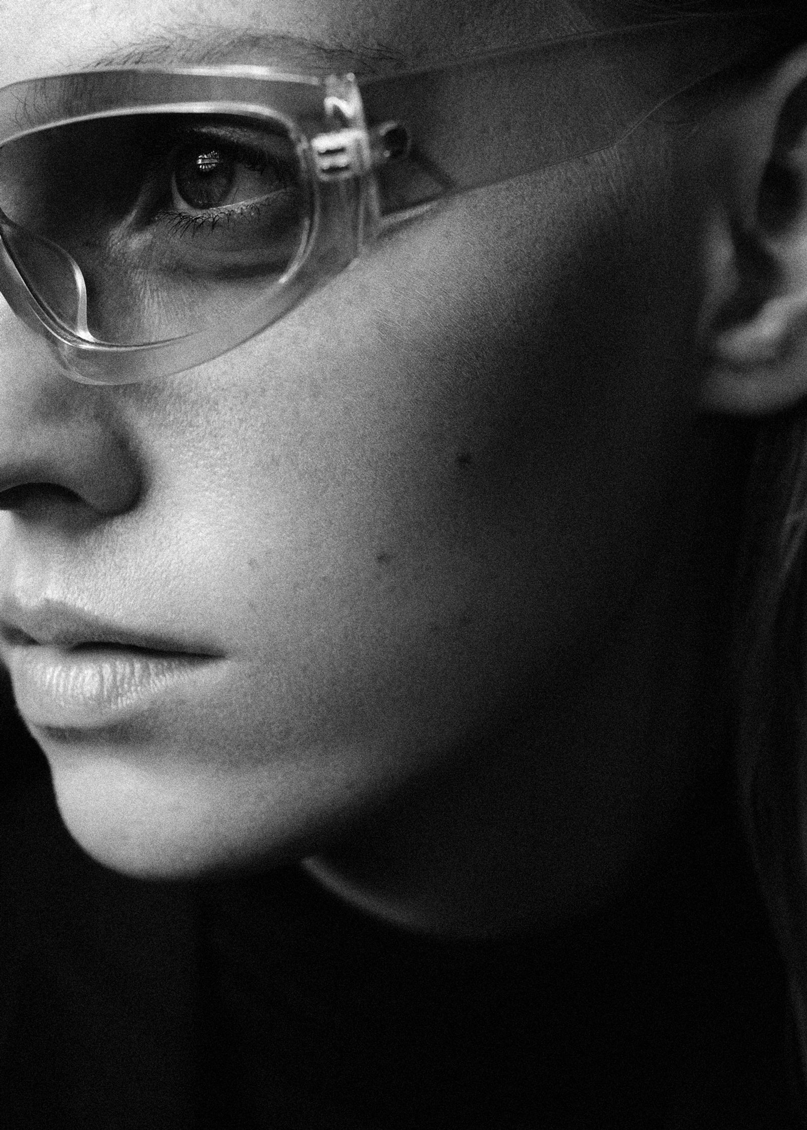 a black and white photo of a woman wearing glasses