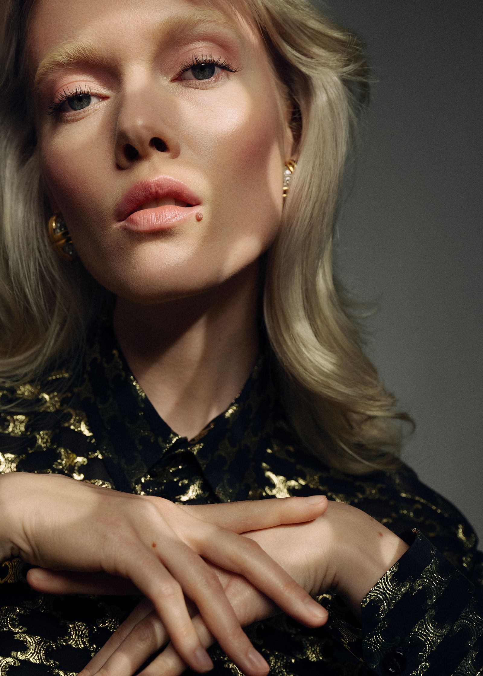 a blonde woman in a gold dress posing for a photo shoot