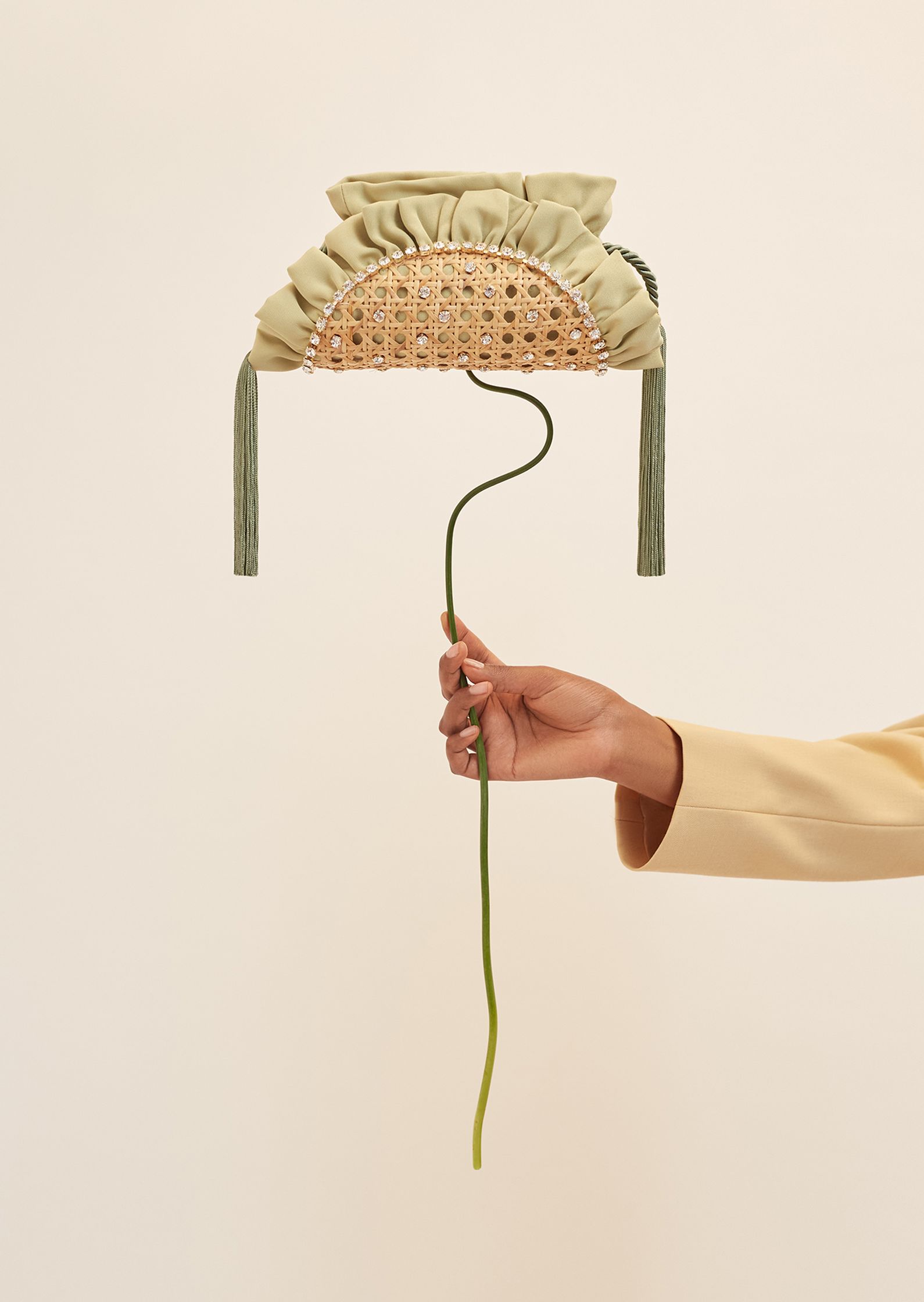 a hand holding a basket with a flower in it