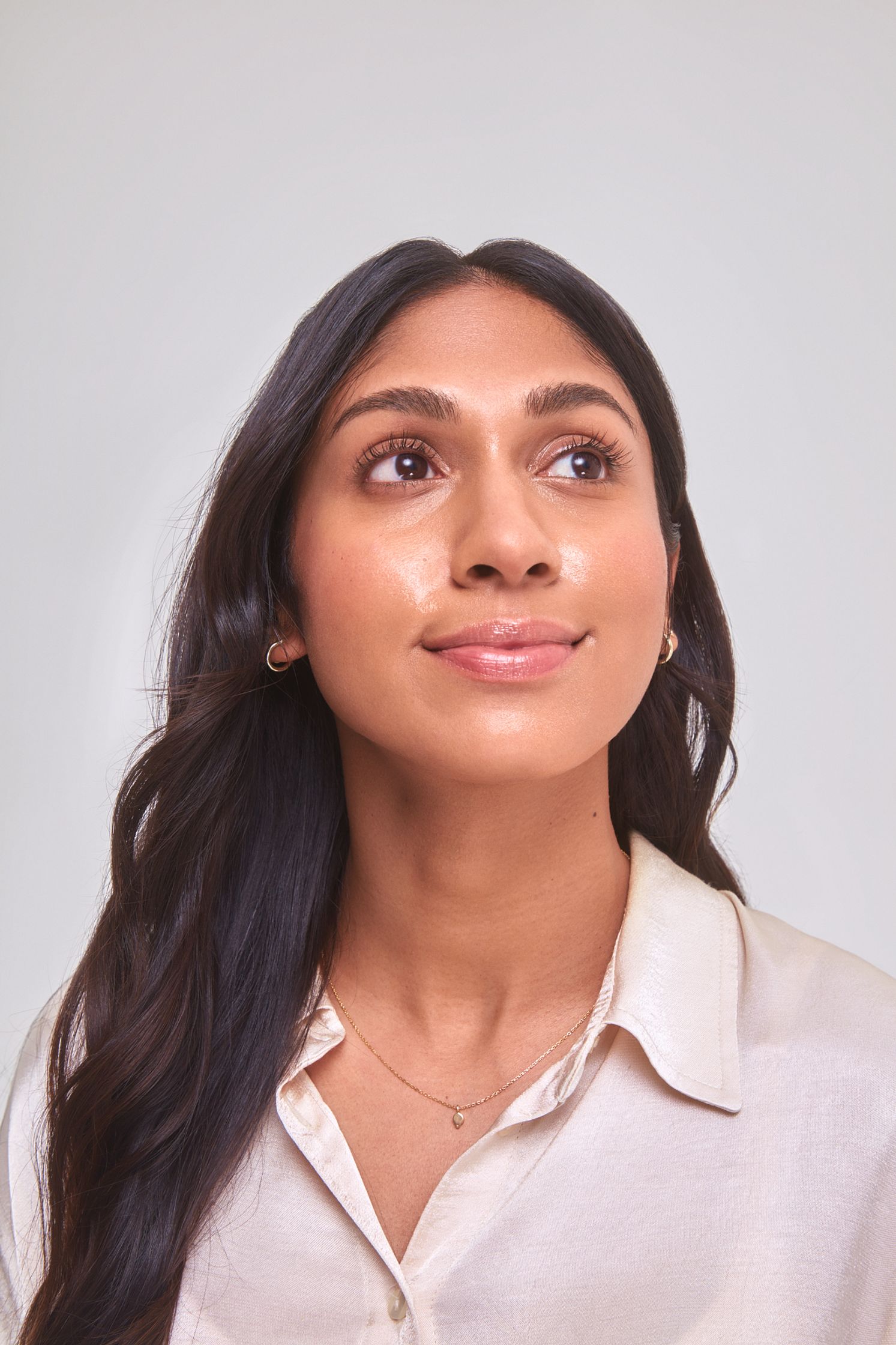 a woman in a white shirt looking up at the sky