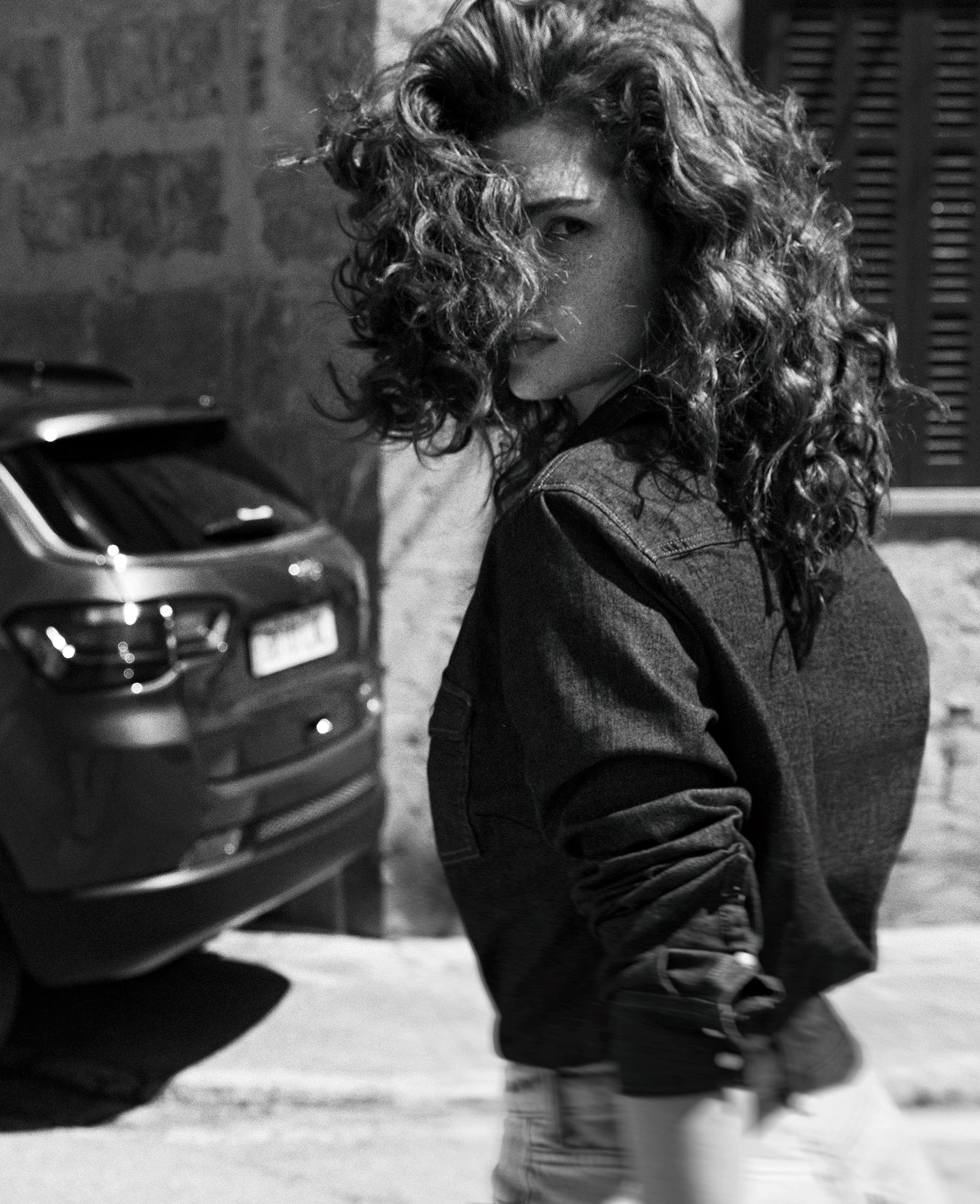 a black and white photo of a woman with curly hair