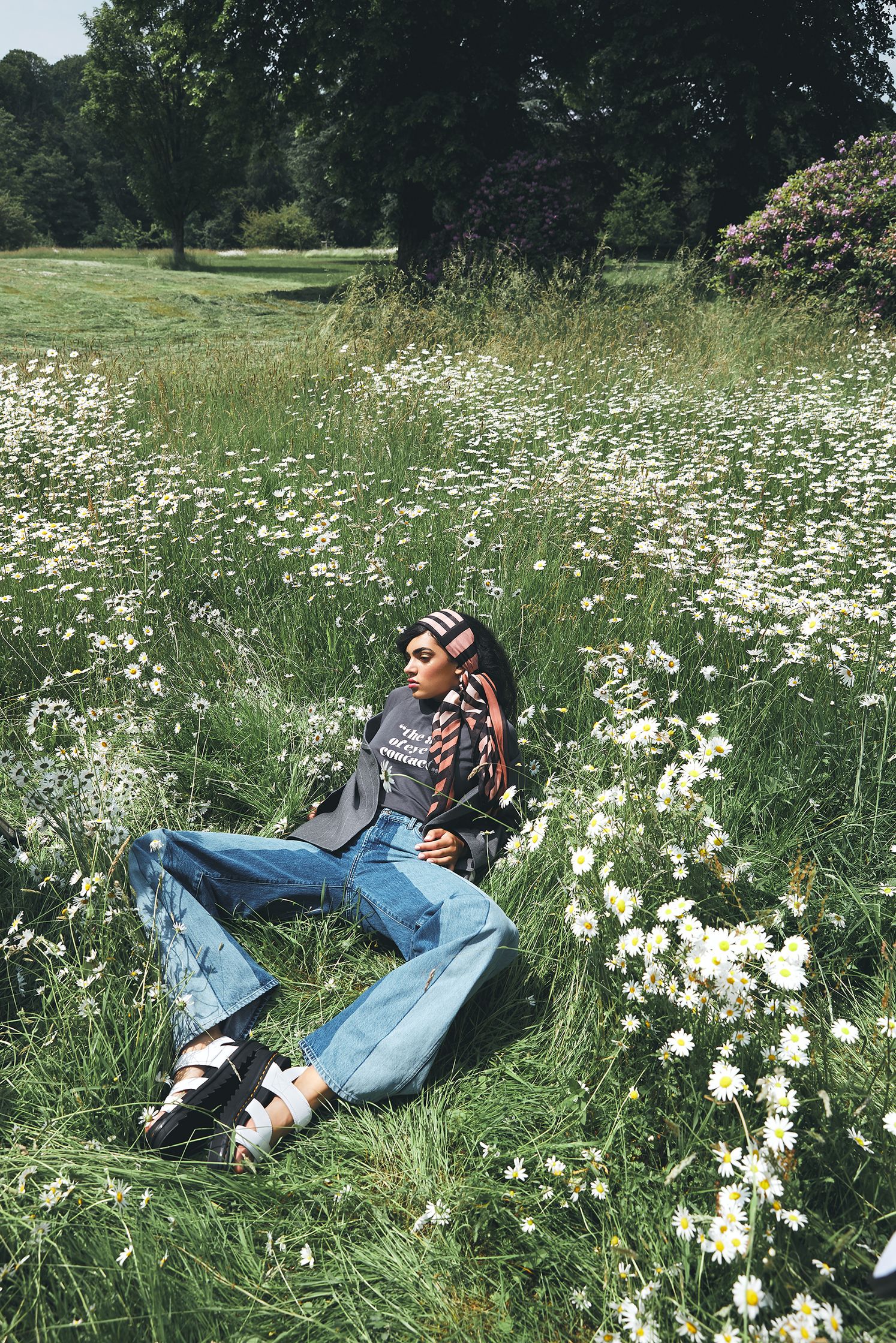 a person laying in a field of daisies