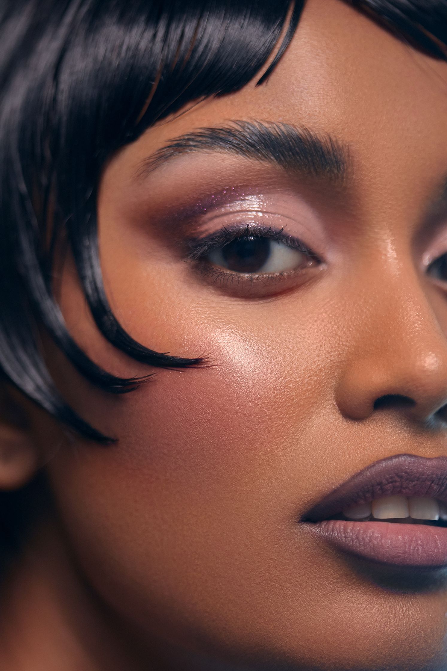 a woman with black hair and makeup
