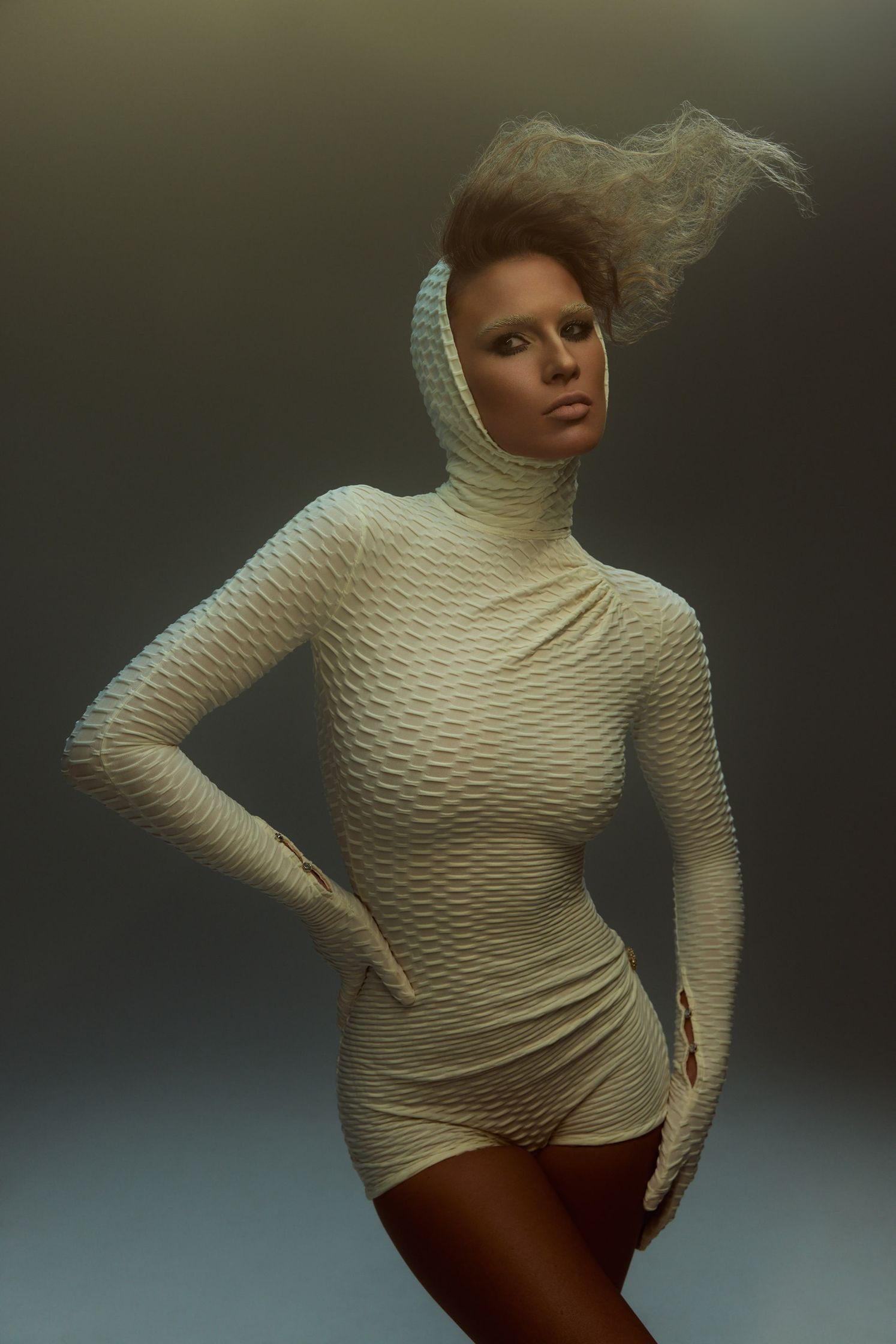 a woman in a white bodysuit posing