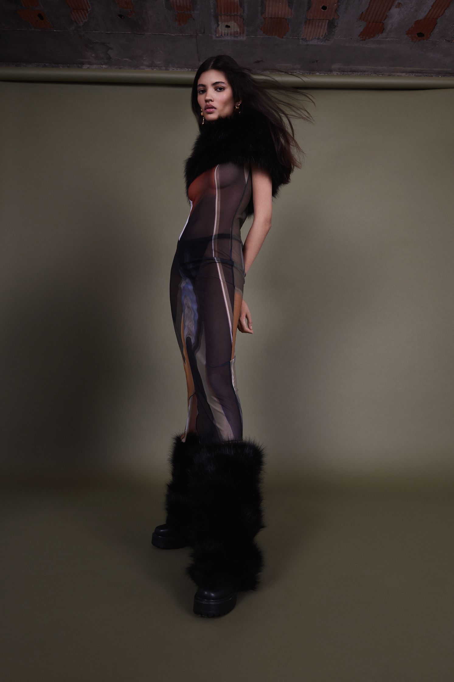 a woman wearing a black jumpsuit and furry boots