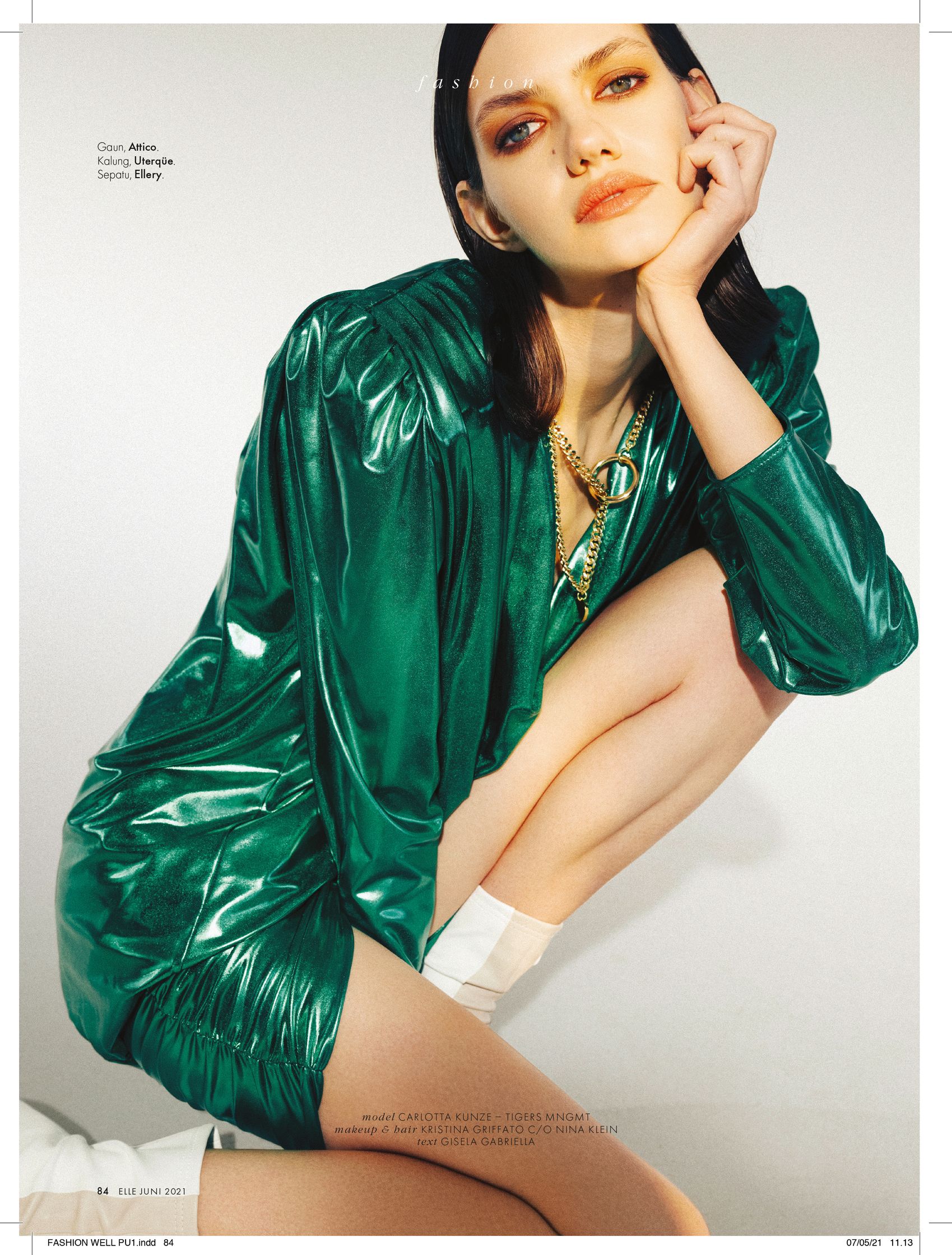 a woman in a green dress is posing for a magazine